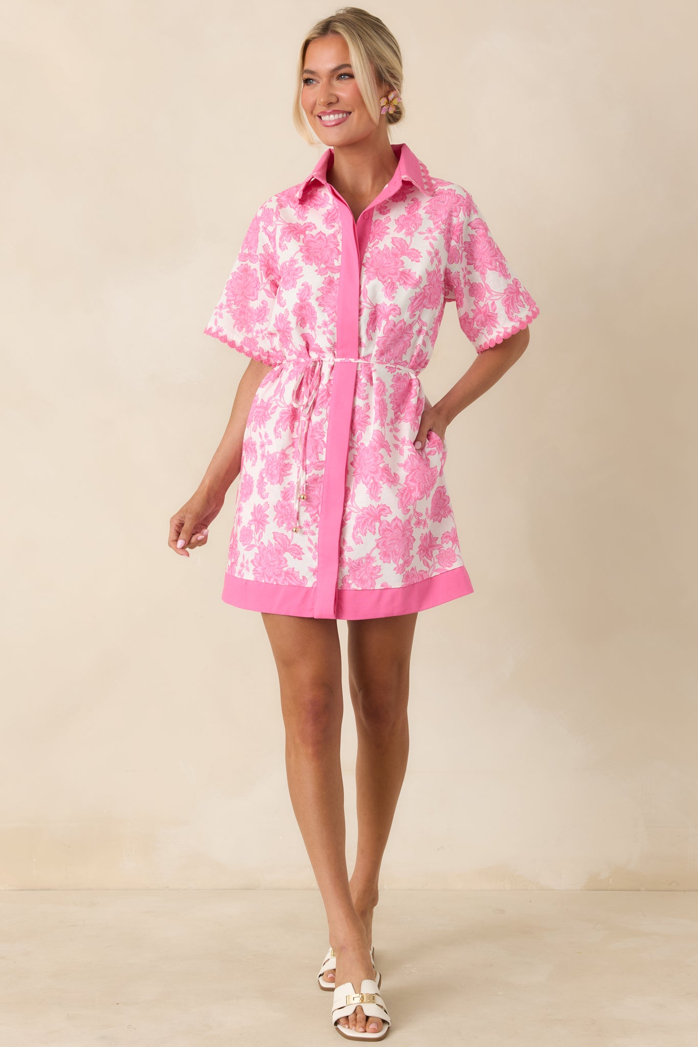 Feminine floral mini dress with scalloped sleeves, collared neckline, and structured fit.
