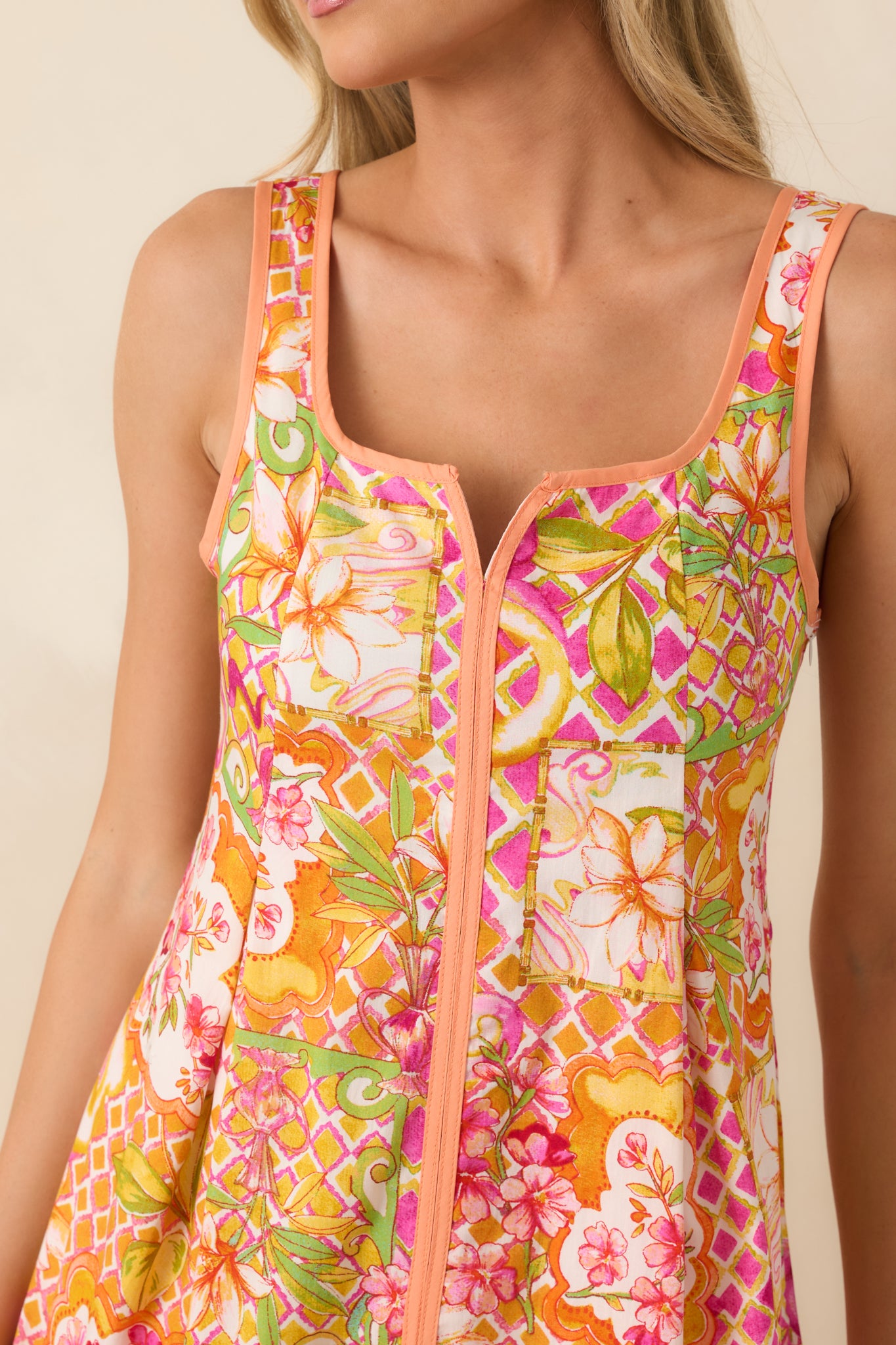Close-up of the floral patchwork print highlighting the contrast trim accents, notched square neckline, and 100% cotton fabric.