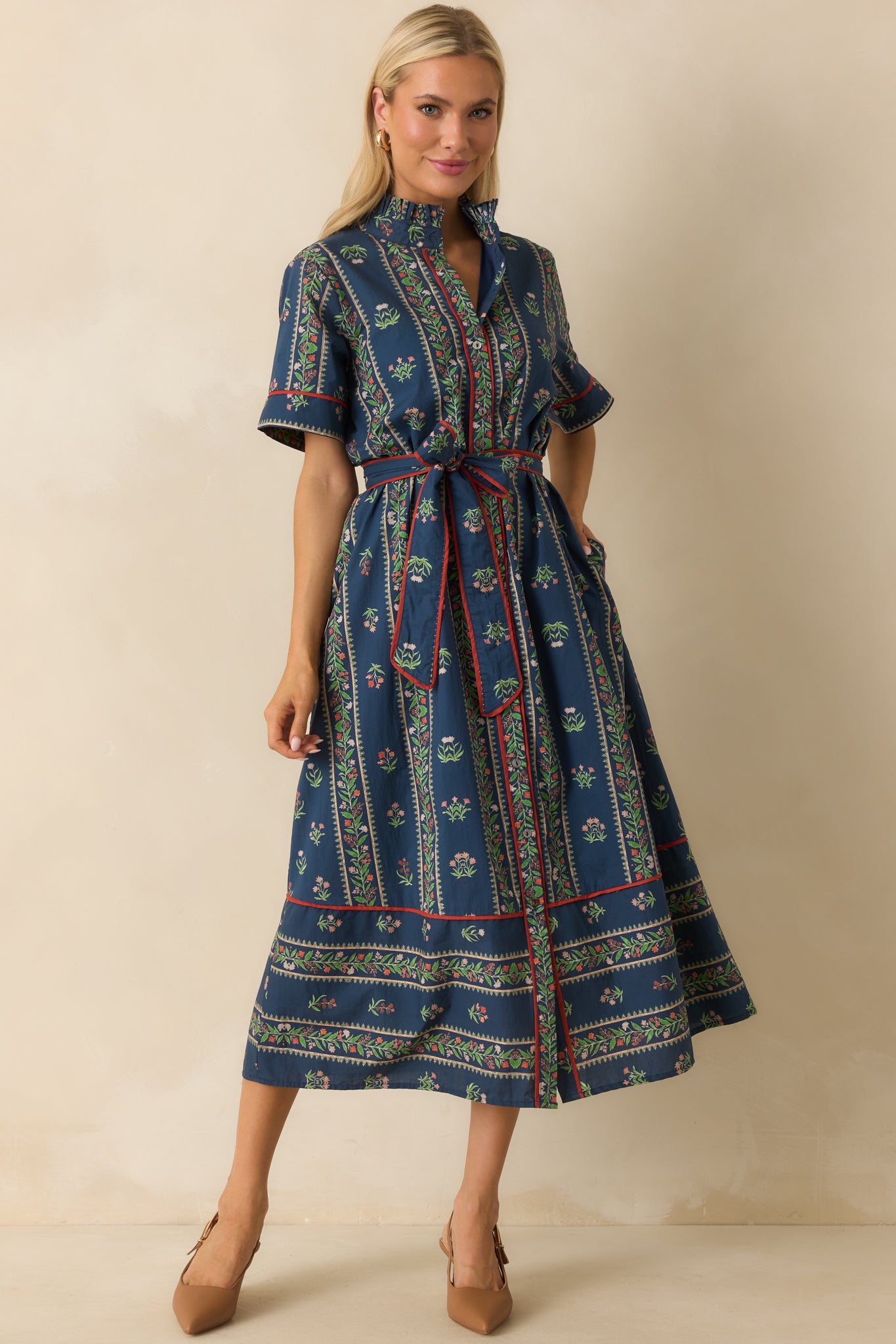 Floral print dress with contrast red piping trim and functional pockets.