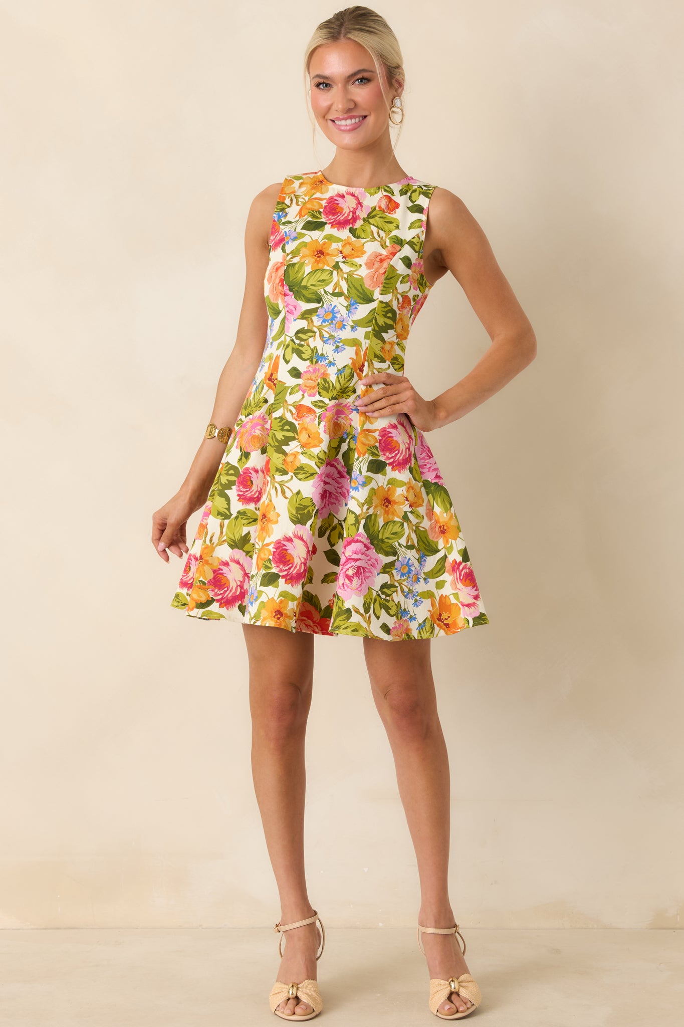 Floral print mini dress on an ivory base with a fitted top and softly flared skirt, creating a feminine shape.