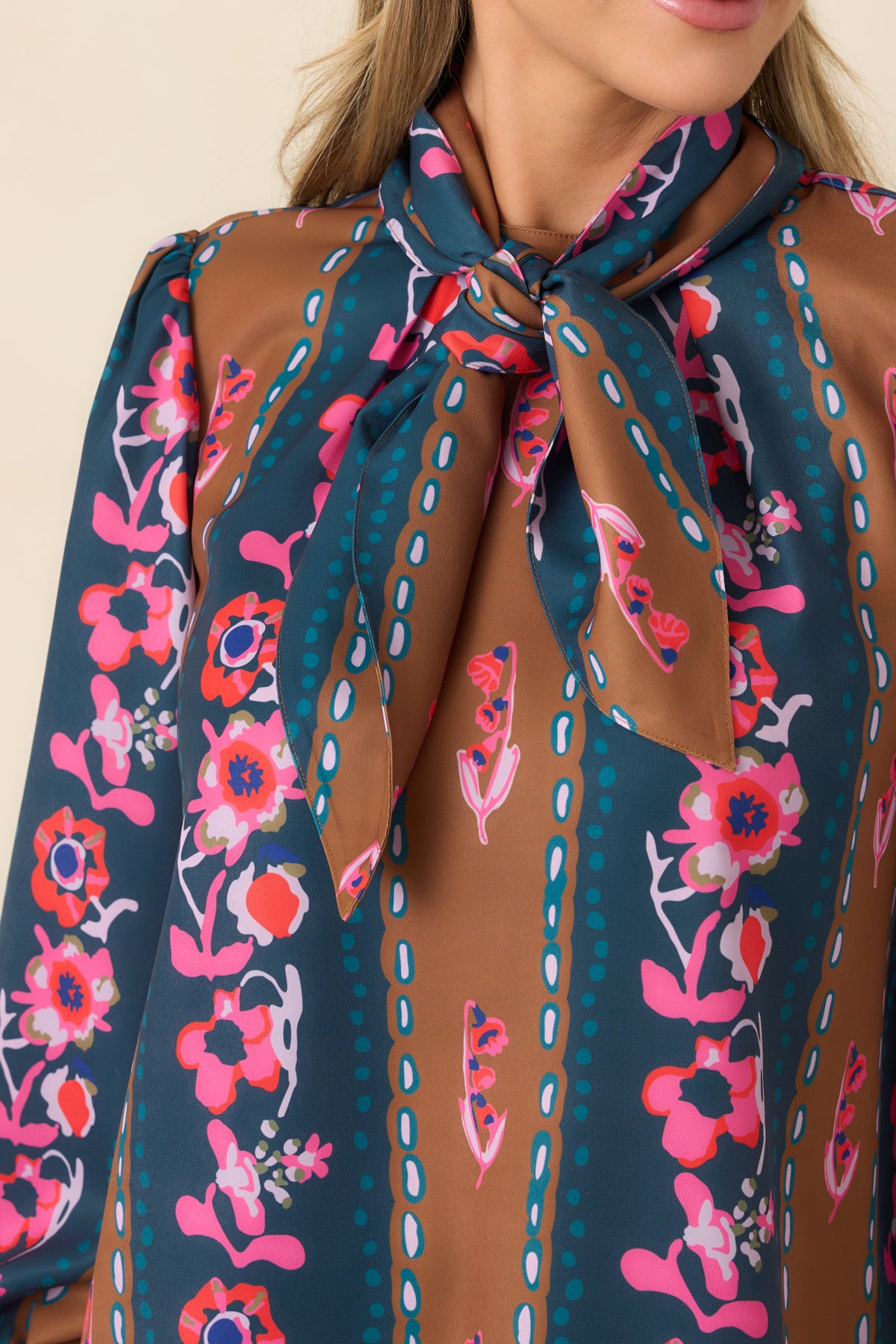 Floral print, removable neck tie, and delicate dotted motifs highlight the detailed design of the striped top.