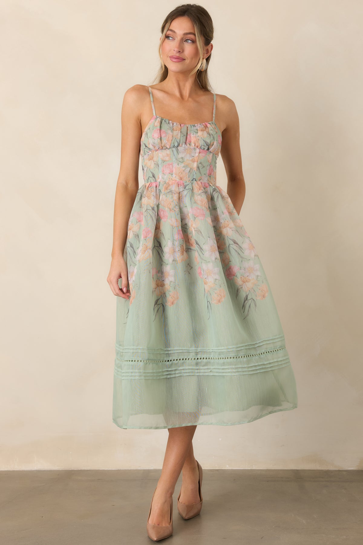 Floral sage green dress featuring a defined waist and softly gathered skirt.
