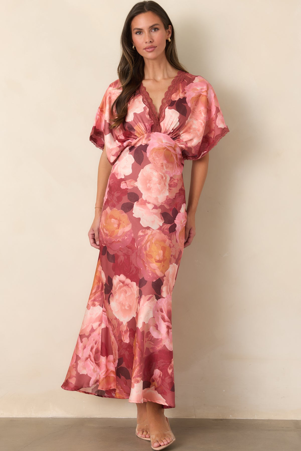 Lustrous satin maxi dress featuring oversized blush, rose, and warm coral florals, lace trim, and a defined waist.