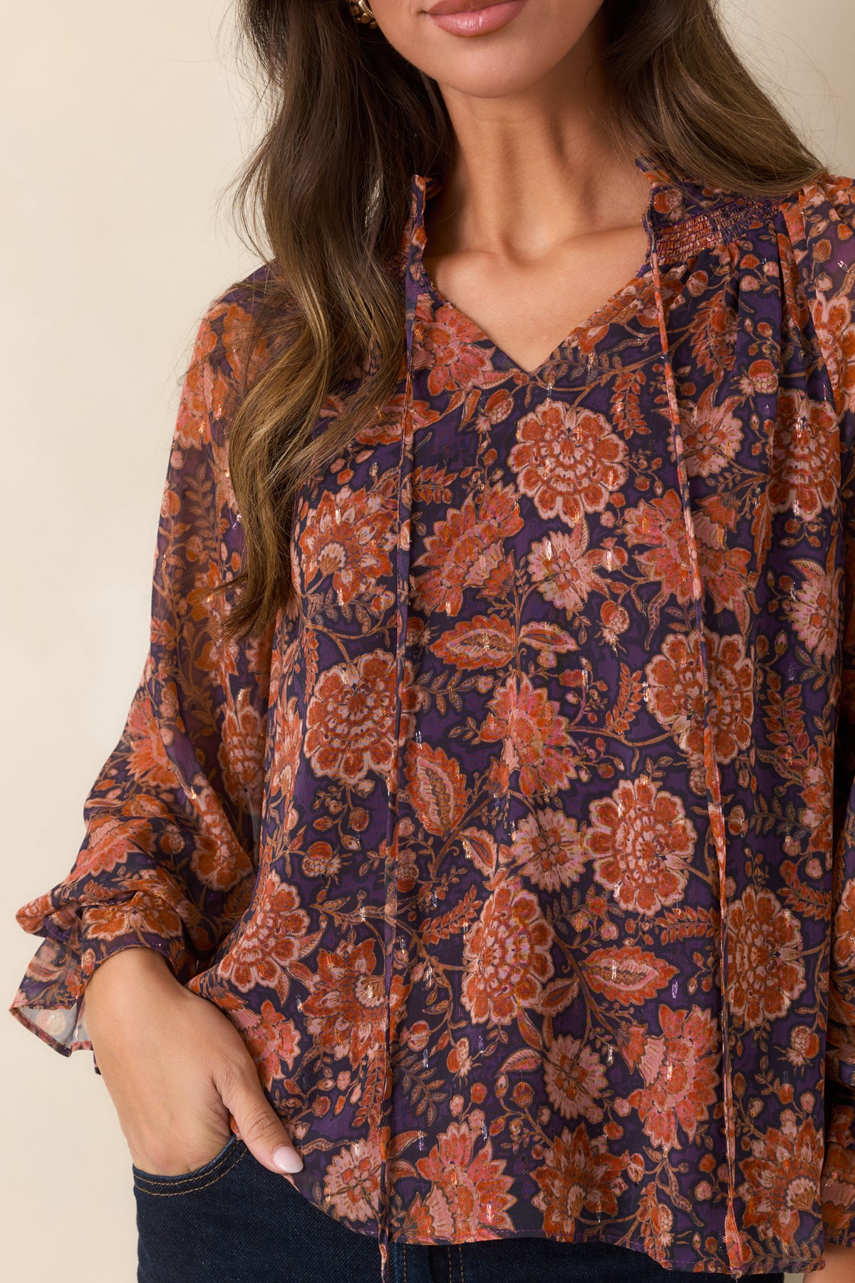 Close-up of the floral top showing the ruffled split neckline, delicate ties, and sheer patterned fabric.