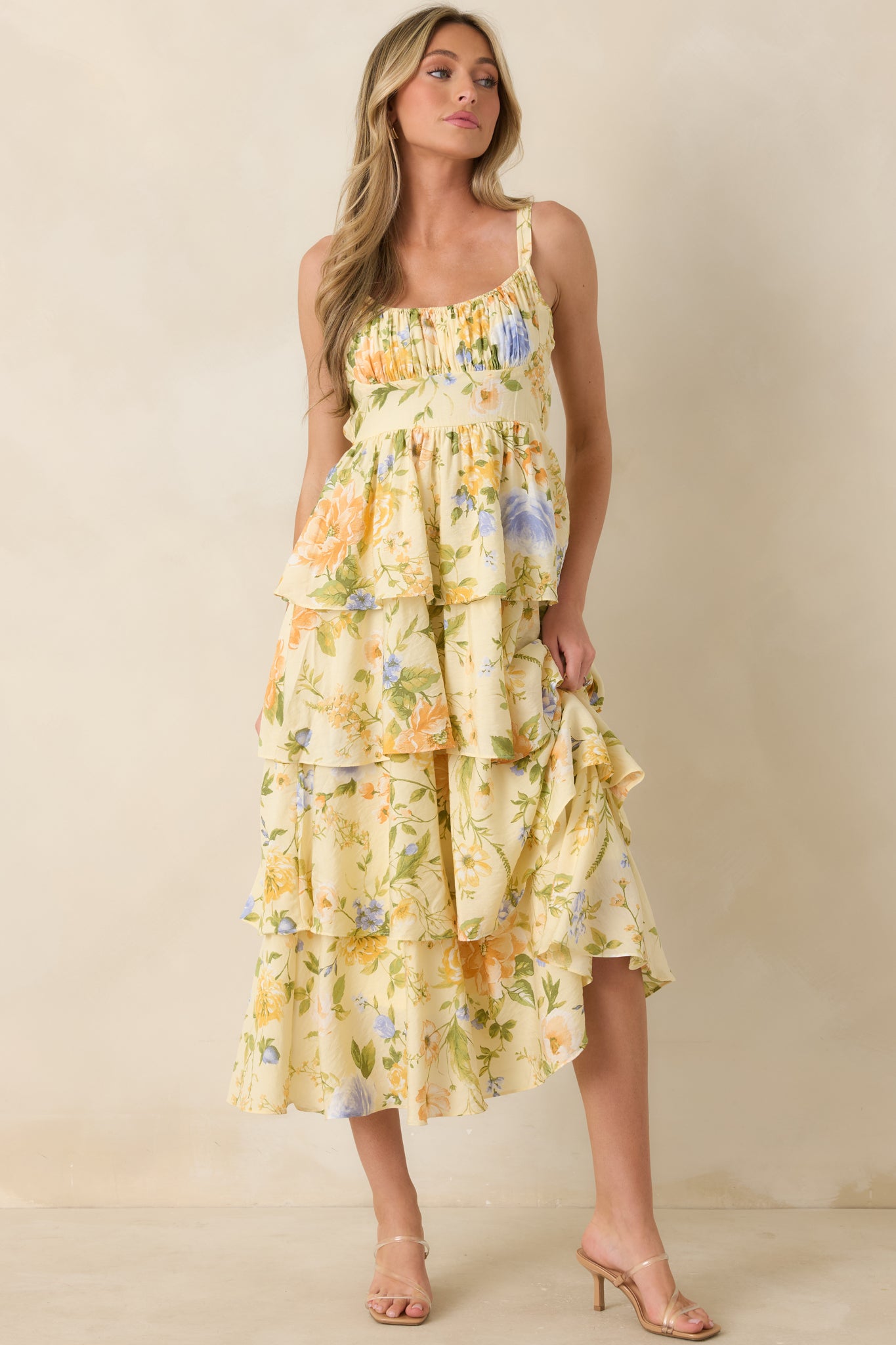 Maxi dress featuring a feminine gathered neckline, vibrant floral pattern, tiered skirt layers, and lightweight flowing shape.