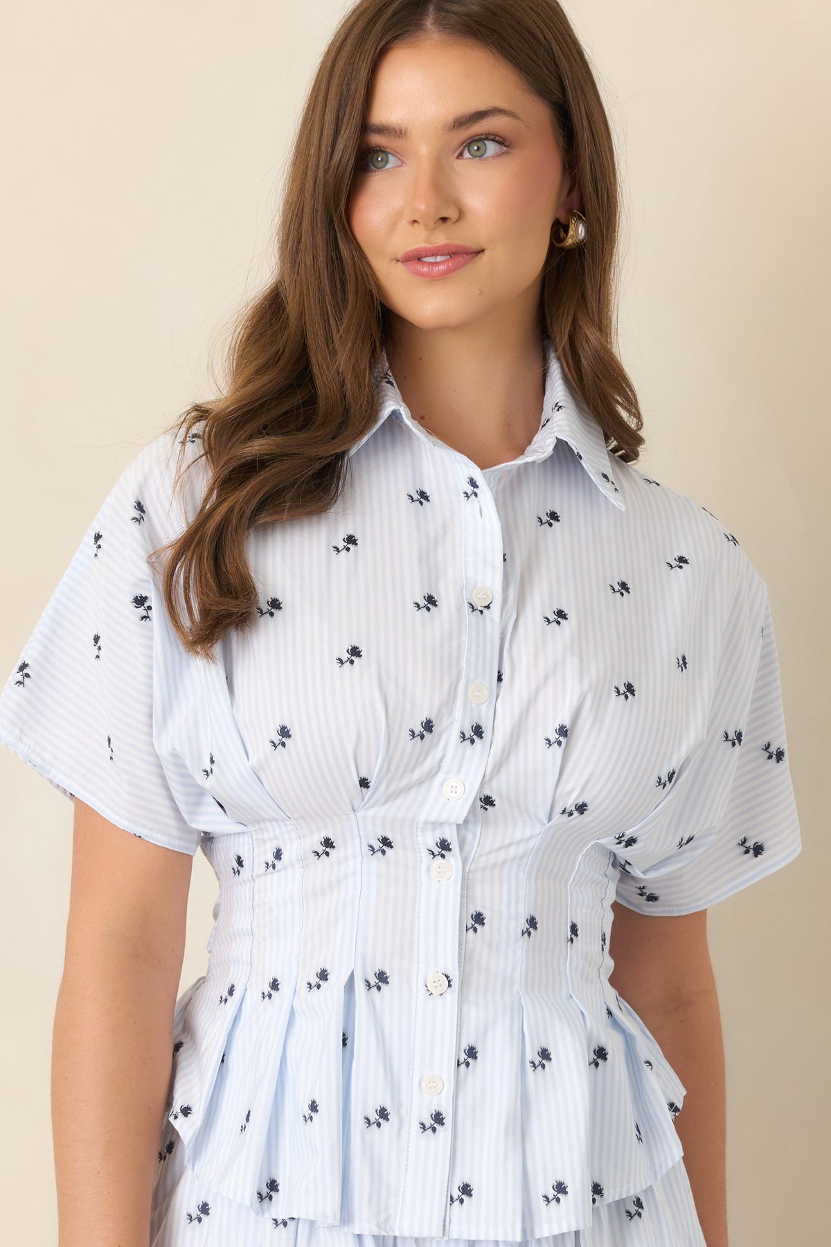 Floral top highlighting the full button-front closure and relaxed short dolman sleeves.