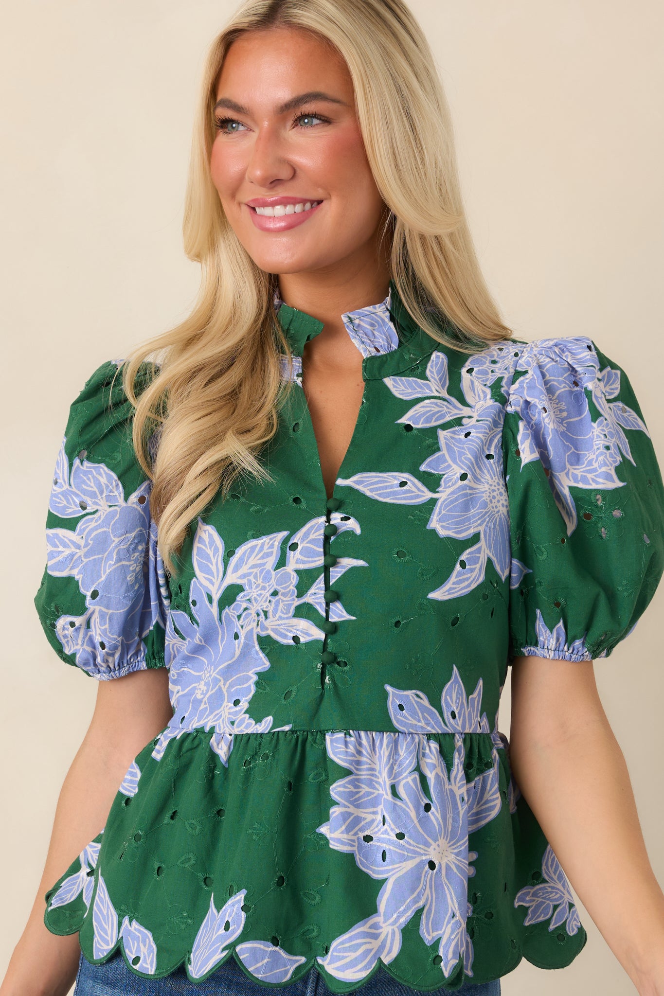 Detailed view of the floral-print top highlighting its scalloped hem and intricate eyelet embroidery.