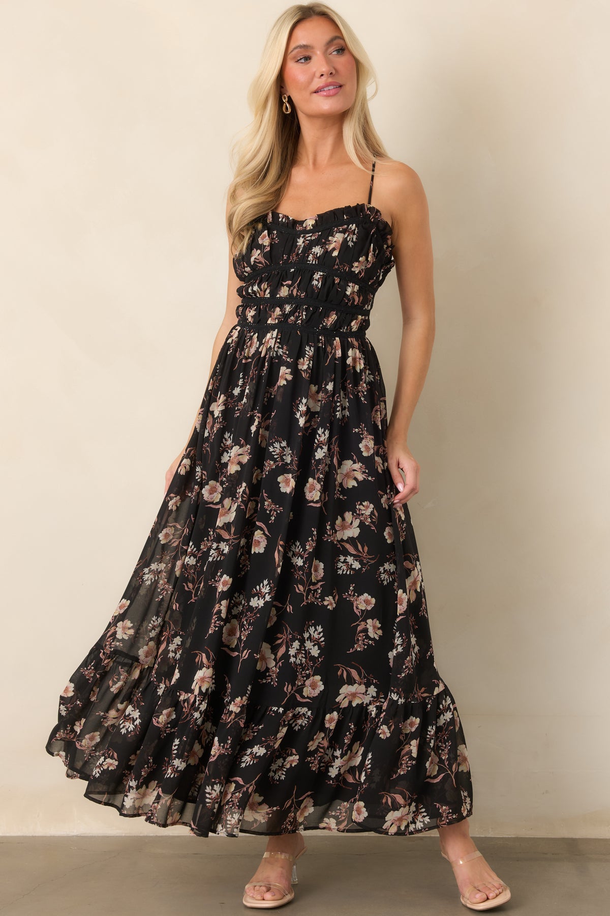 Flowing dress with muted blush and ivory blooms scattered over a sheer black layer and gathered bodice.