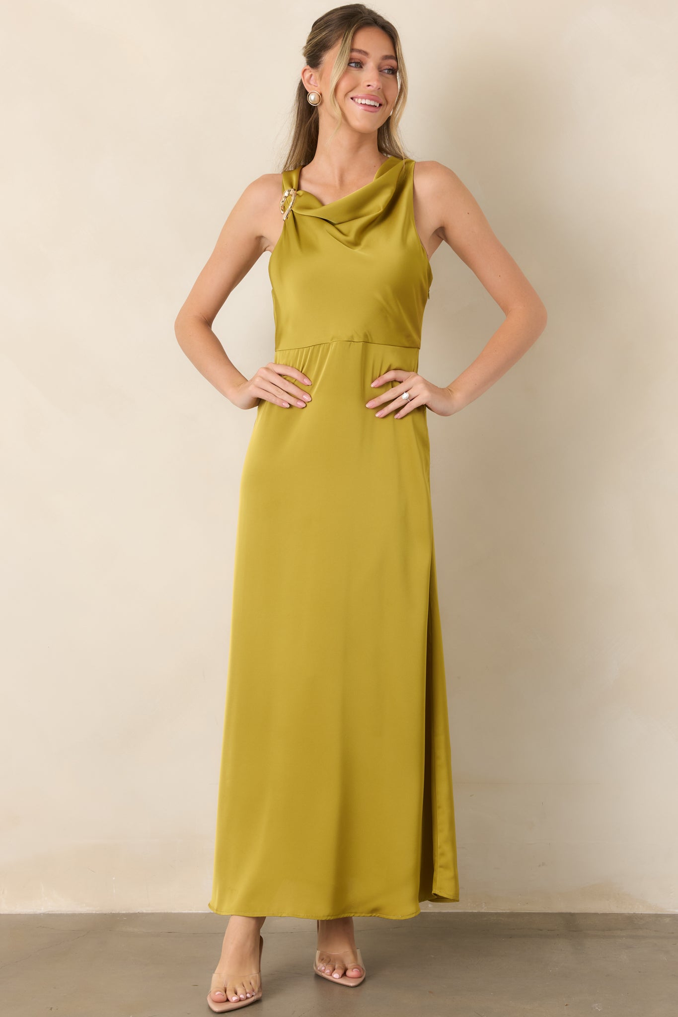 Flowing satin maxi dress featuring a graceful neckline, structured gold-tone shoulder embellishment, and softly skimming A-line skirt.