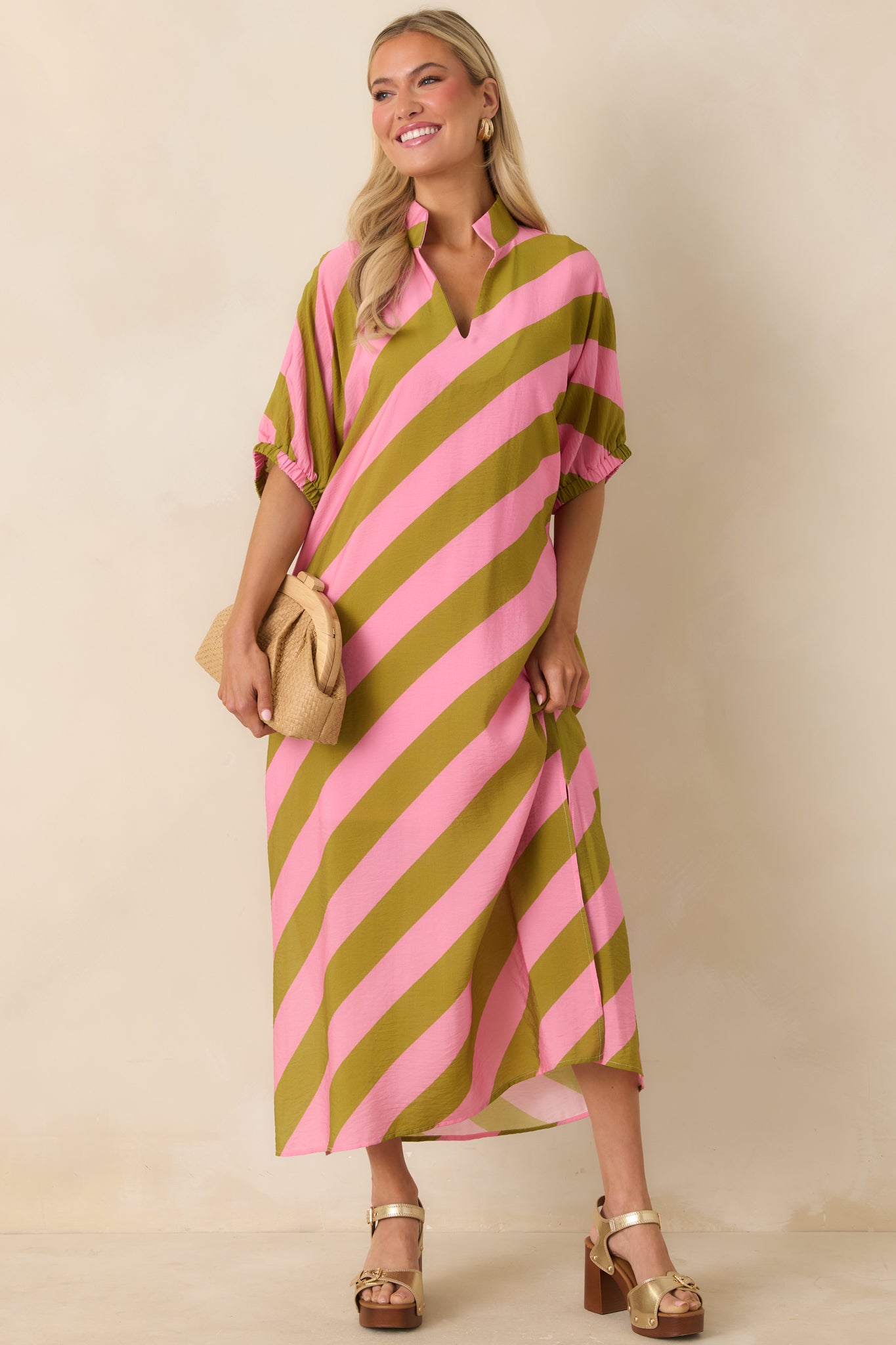 Flowing striped maxi dress featuring short dolman sleeves with elastic cuffs and side pockets.