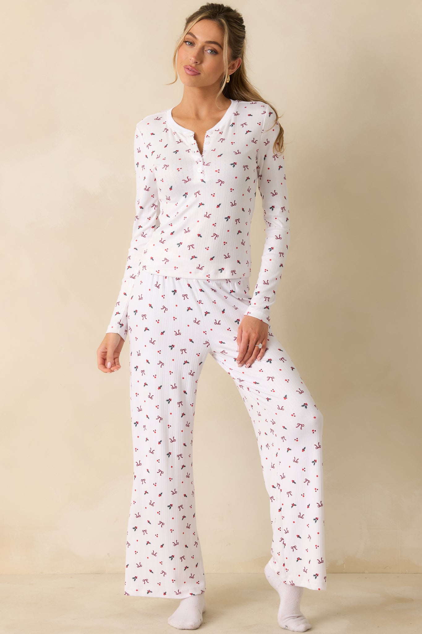 Flowing white pants in soft-wash Pointelle fabric, featuring a festive holly-and-bow pattern and relaxed wide-leg silhouette.