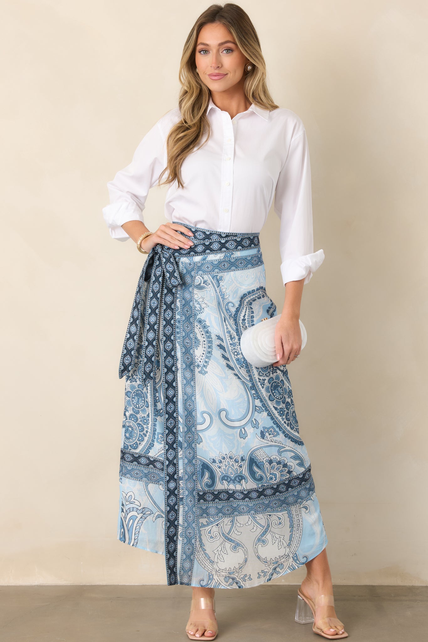 Elegant wrap skirt featuring a graceful maxi length, flowing silhouette, and contrasting printed trim along the lower edge.