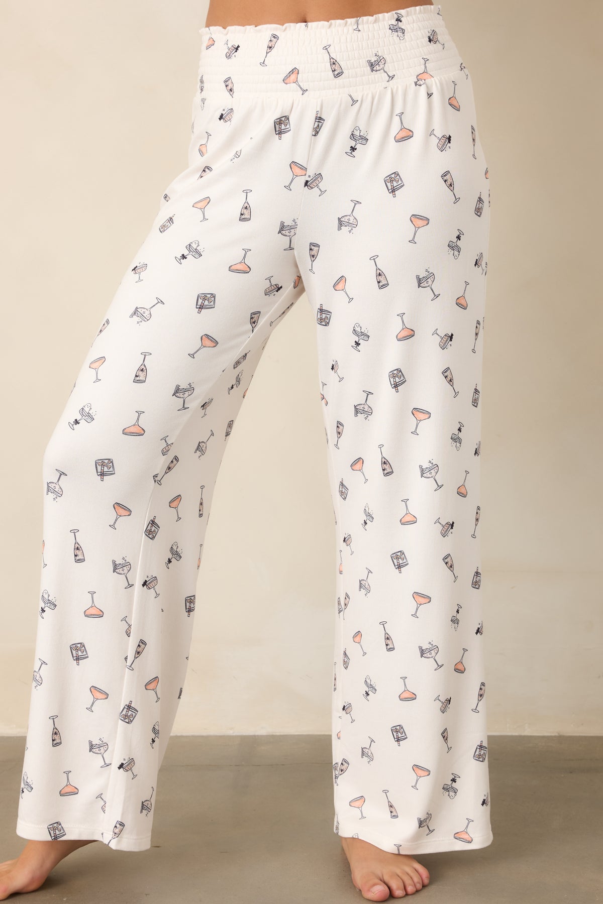 Flowy ivory pants highlighting the relaxed wide-leg shape and playful cocktail print with subtle spooky details.