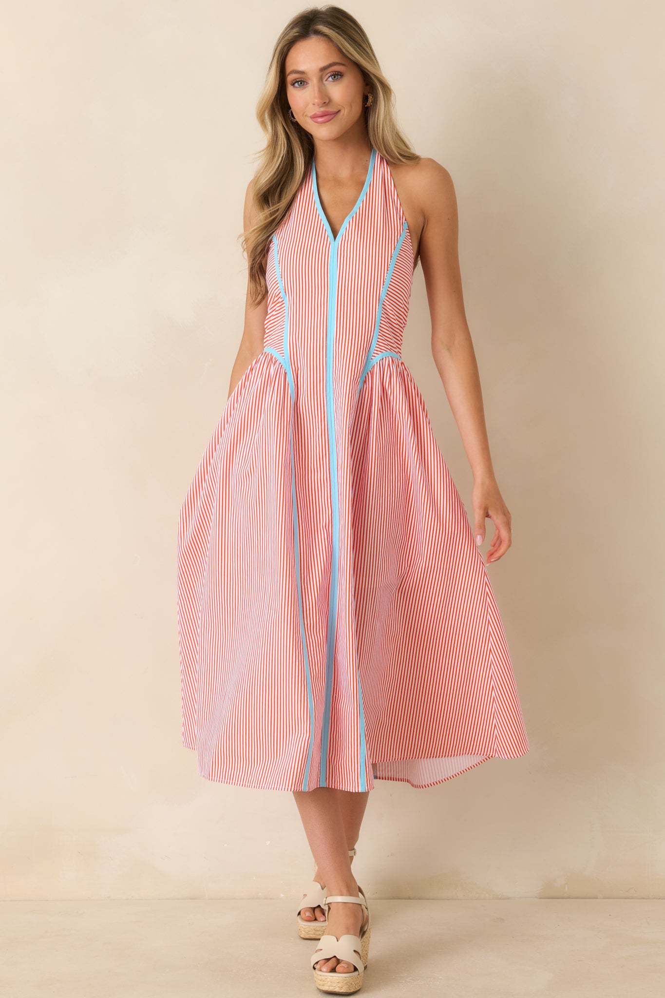 Flowy midi dress with a halter neckline, softly gathered skirt, and polished contrast trim accents.
