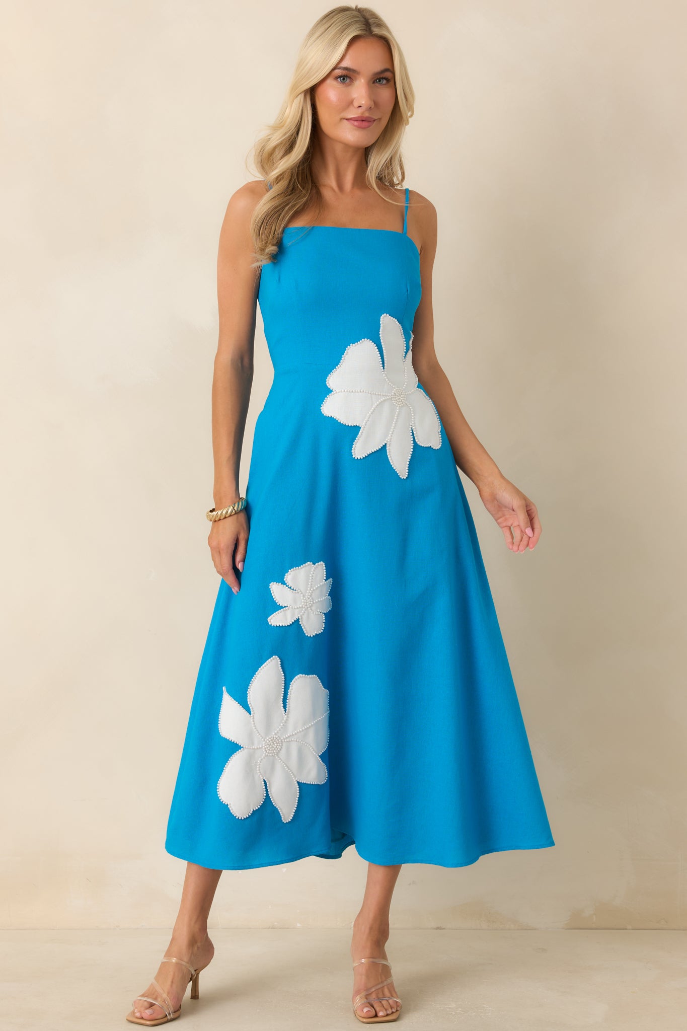 Flowy midi dress featuring adjustable shoulder straps, a structured bodice, and a softly draped skirt.
