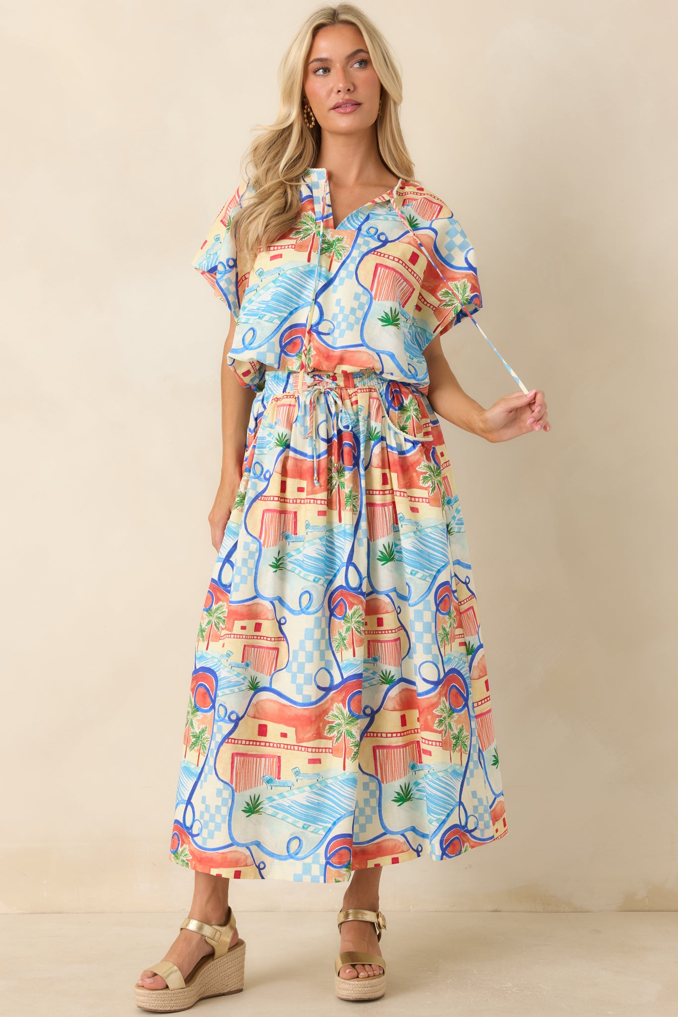 Flowy skirt with a colorful scenic print, roomy side pockets, and a relaxed midi-length design.