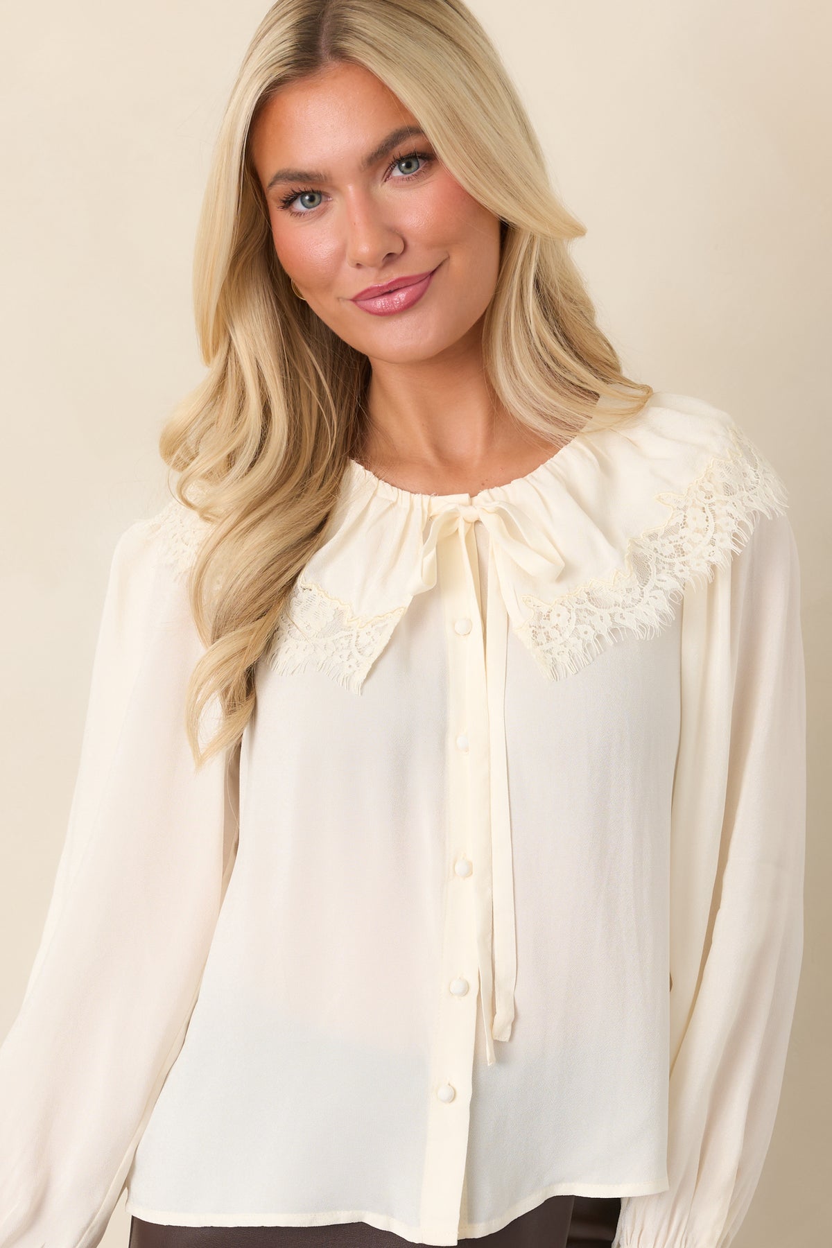 Fluid blouse with intricate tonal lace detailing and a softly gathered neckline.
