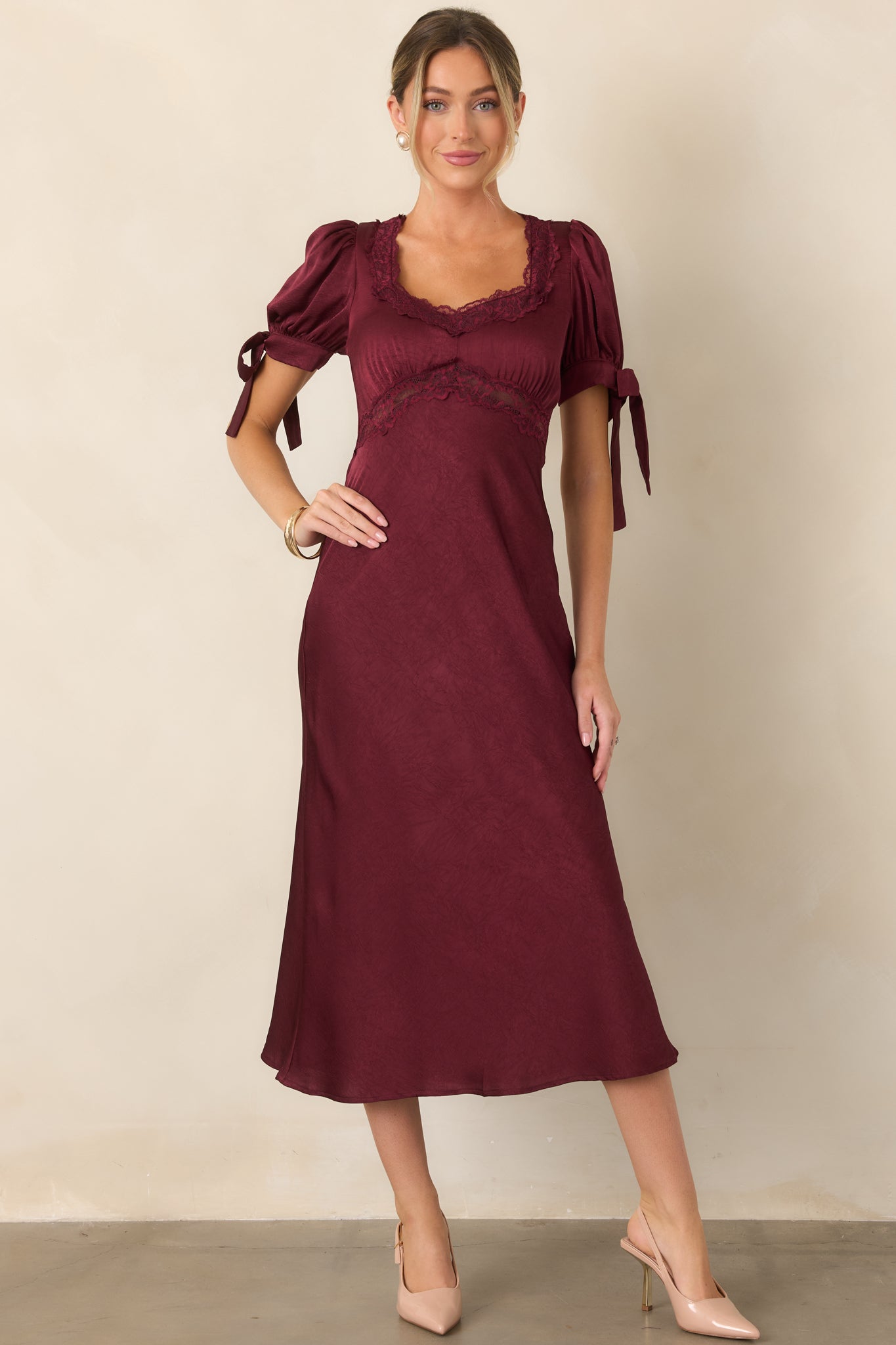 Fluid jewel-tone dress featuring a softly structured bodice, lace-trimmed underbust seam, puffed sleeves, and an effortlessly flowing midi skirt.