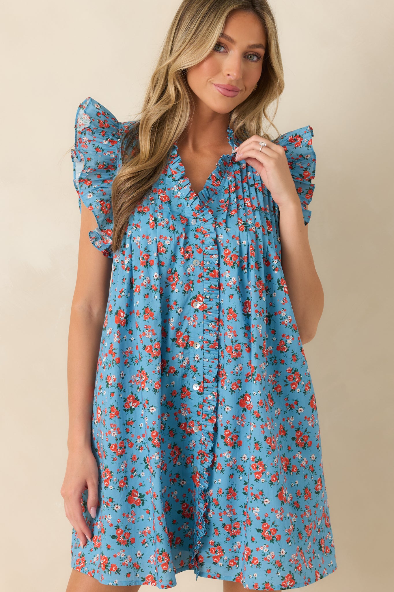 Matching flutter sleeves create a lightweight, feminine finish on this relaxed floral cotton mini dress.