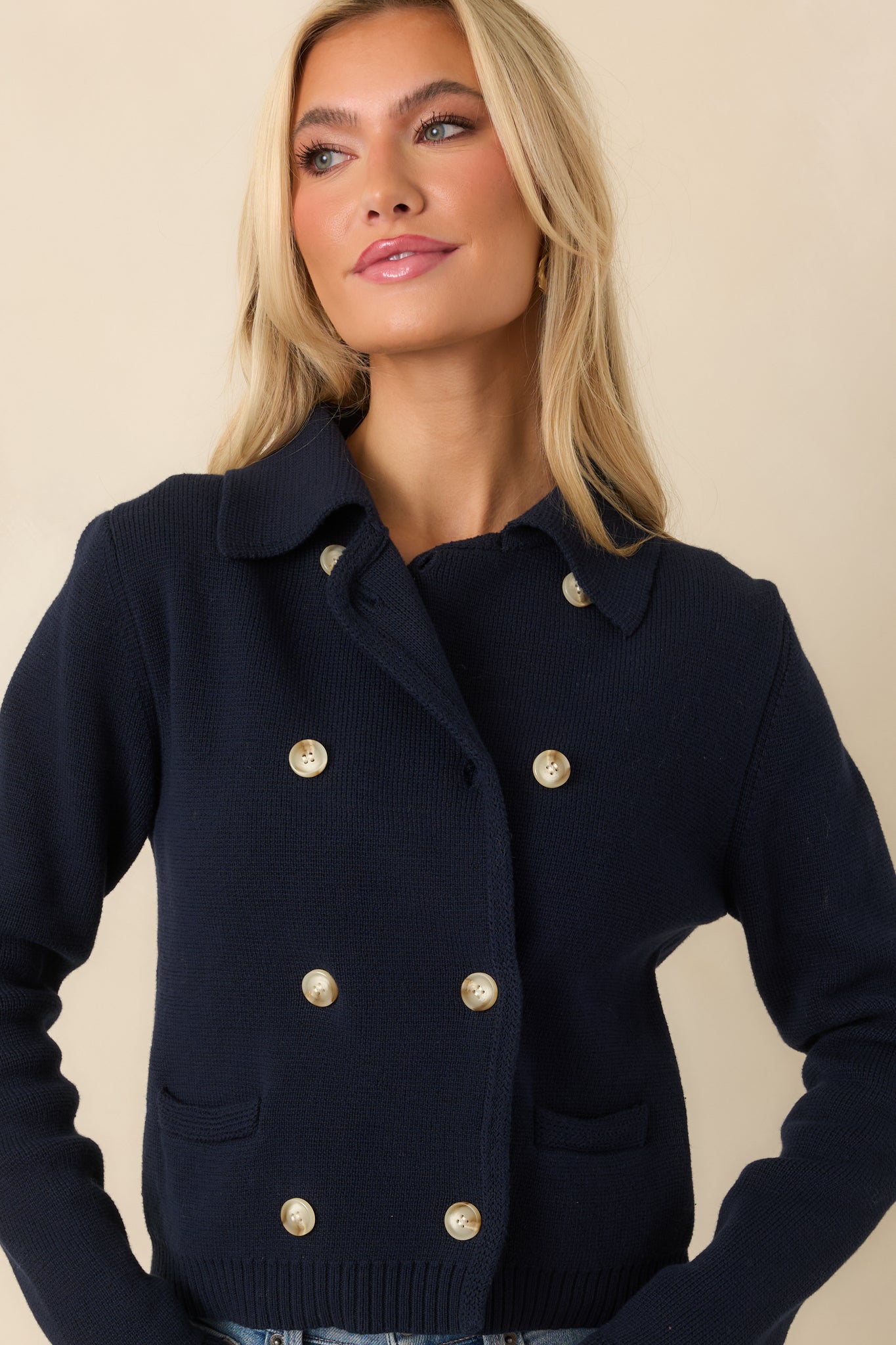 Focus on the front patch pocket and ribbed trim on the navy cardigan.