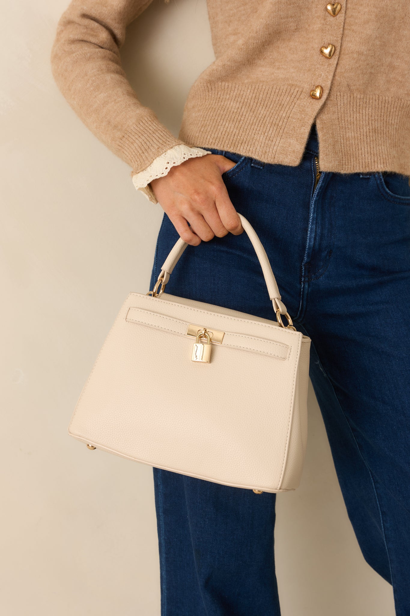Cropped front view focusing on the smooth faux leather texture and structured design of the nude handbag.