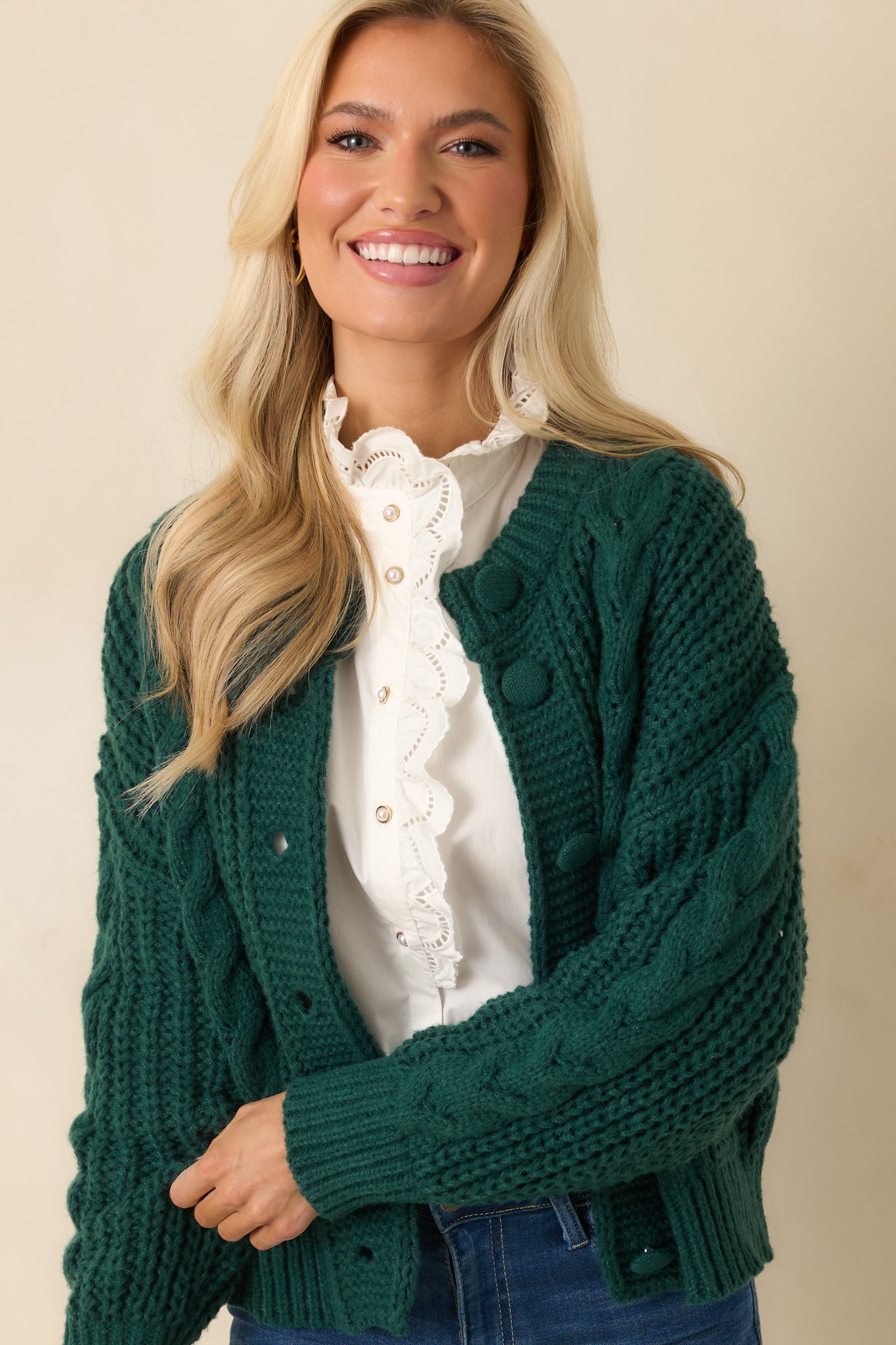 Front crop showing textured cable knit along the torso and button closure details.
