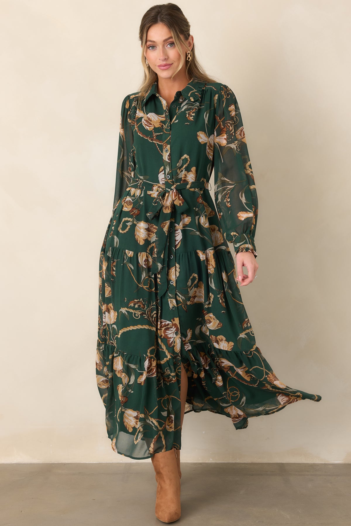Forest green shirt dress with warm-toned floral detailing, a self-tie waist, sheer sleeves, and a graceful tiered maxi-length skirt.
