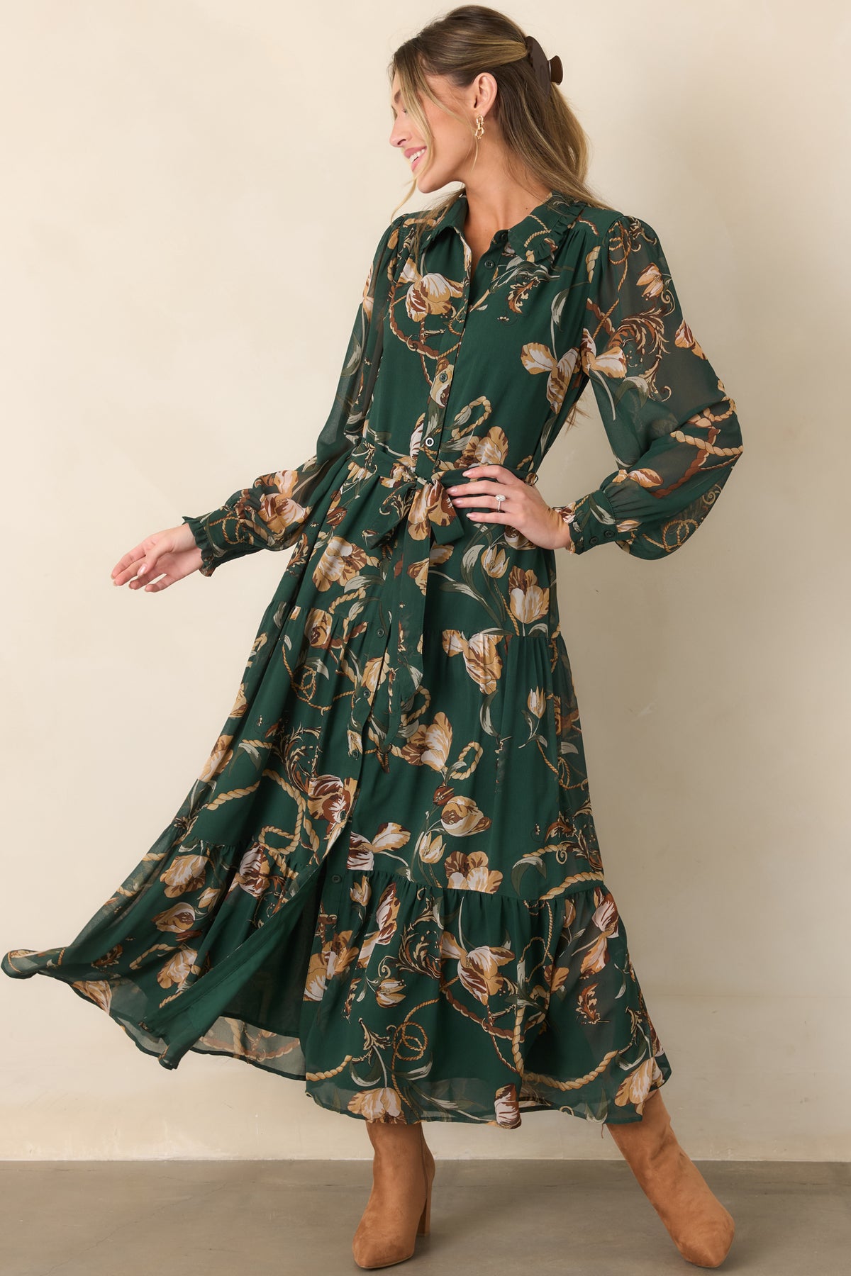 Forest green printed shirt dress highlighting its warm camel and cream accents, adjustable waist tie, flowing tiered skirt, and sheer sleeves.