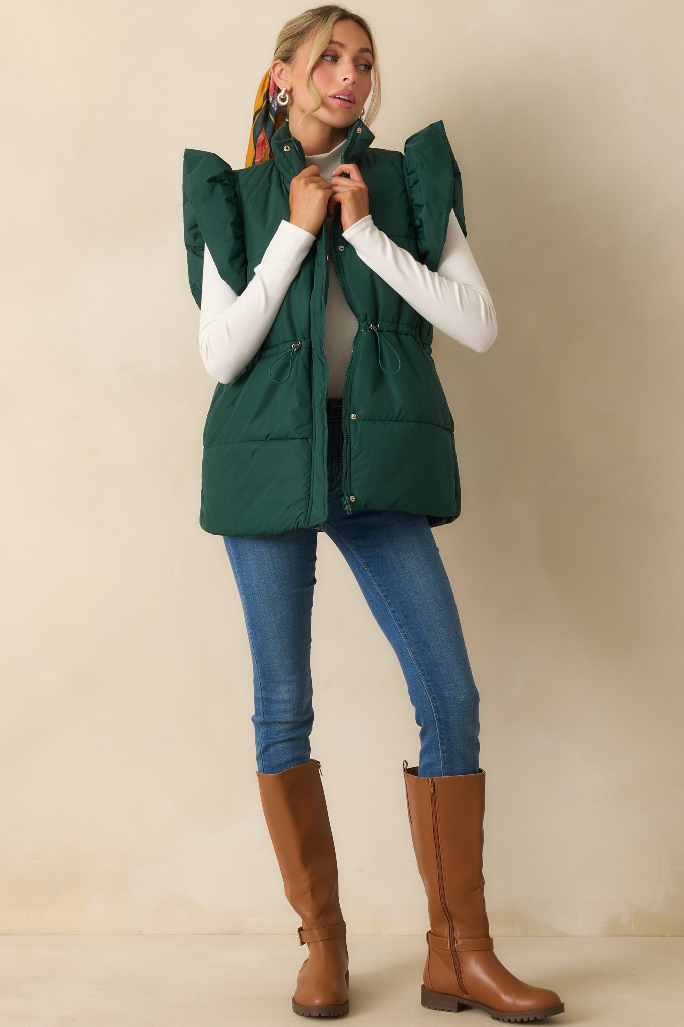 Forest green puffer vest styled with a high neckline and fluffy flutter sleeves.