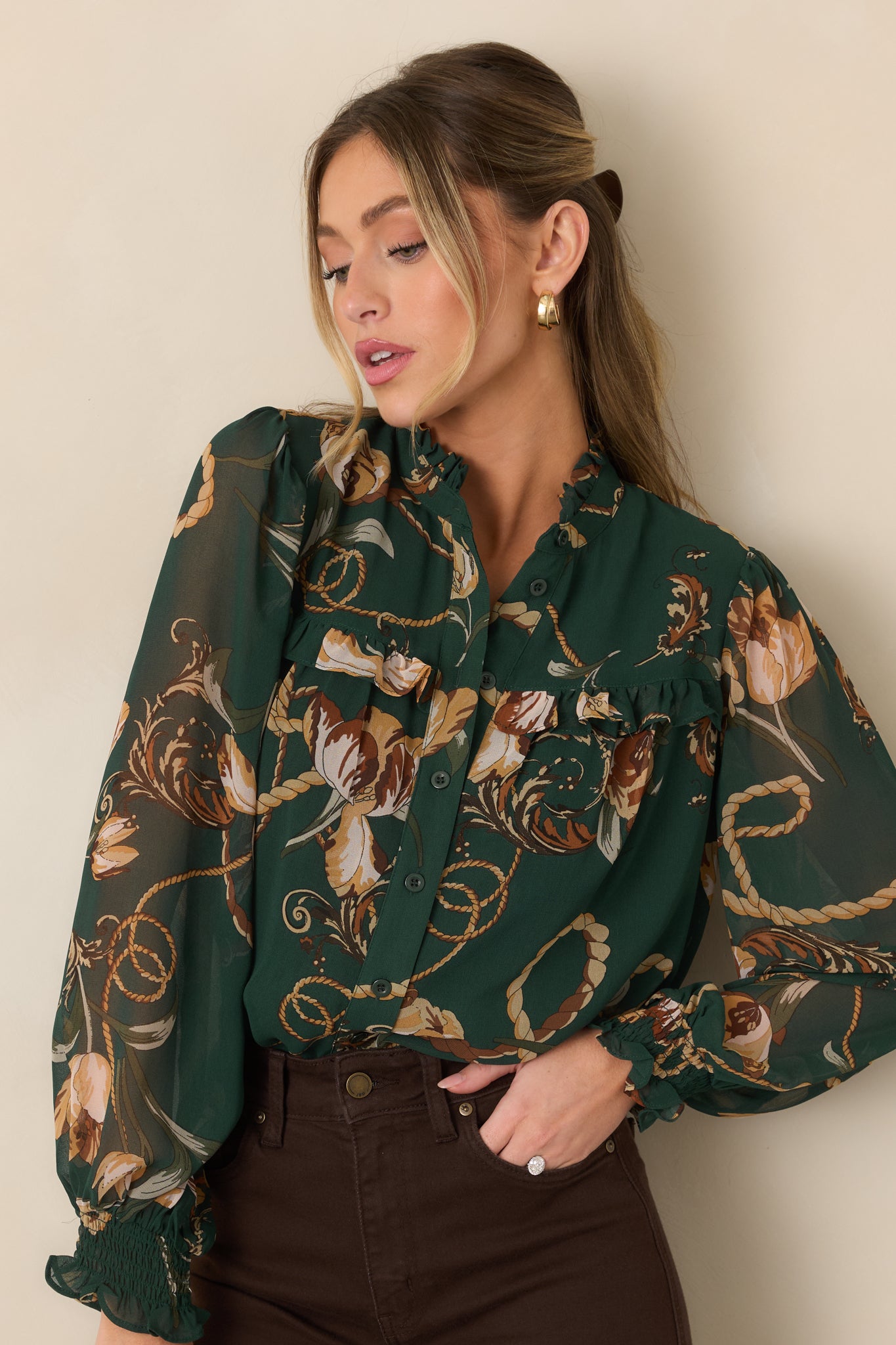 Close view of the forest green blouse highlighting its ruffled neckline, functional buttons, and delicate yoke trim.