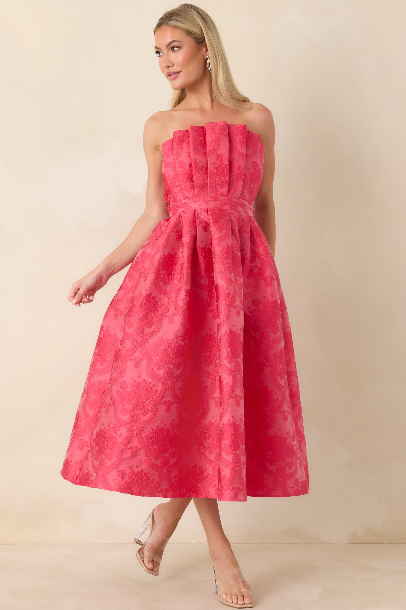 Front angle of pink midi dress emphasizing the fitted bodice and gently pleated skirt.