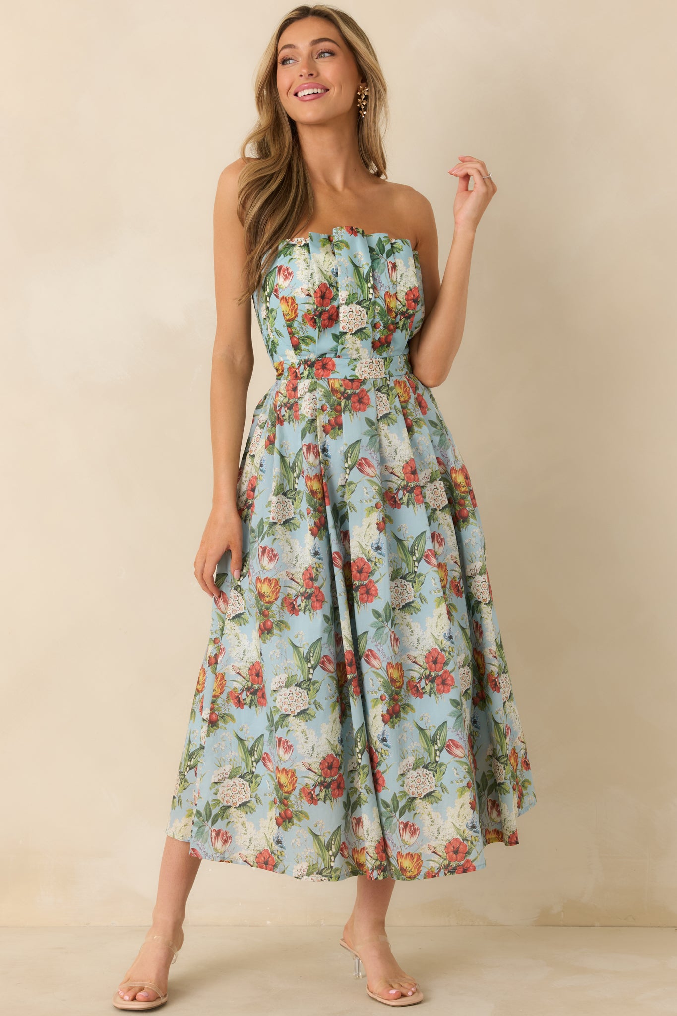 Front-facing angle showing the pleated skirt and vibrant floral pattern on the blue dress.