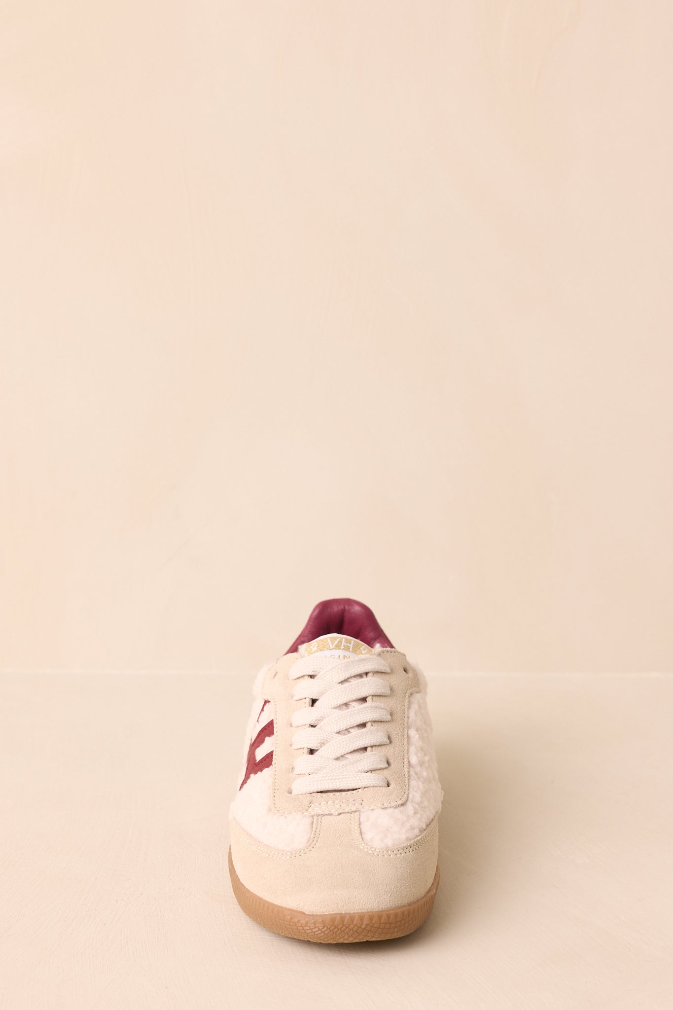 Front angle showing lace-up closure, padded collar, and rich contrast between beige and burgundy panels.