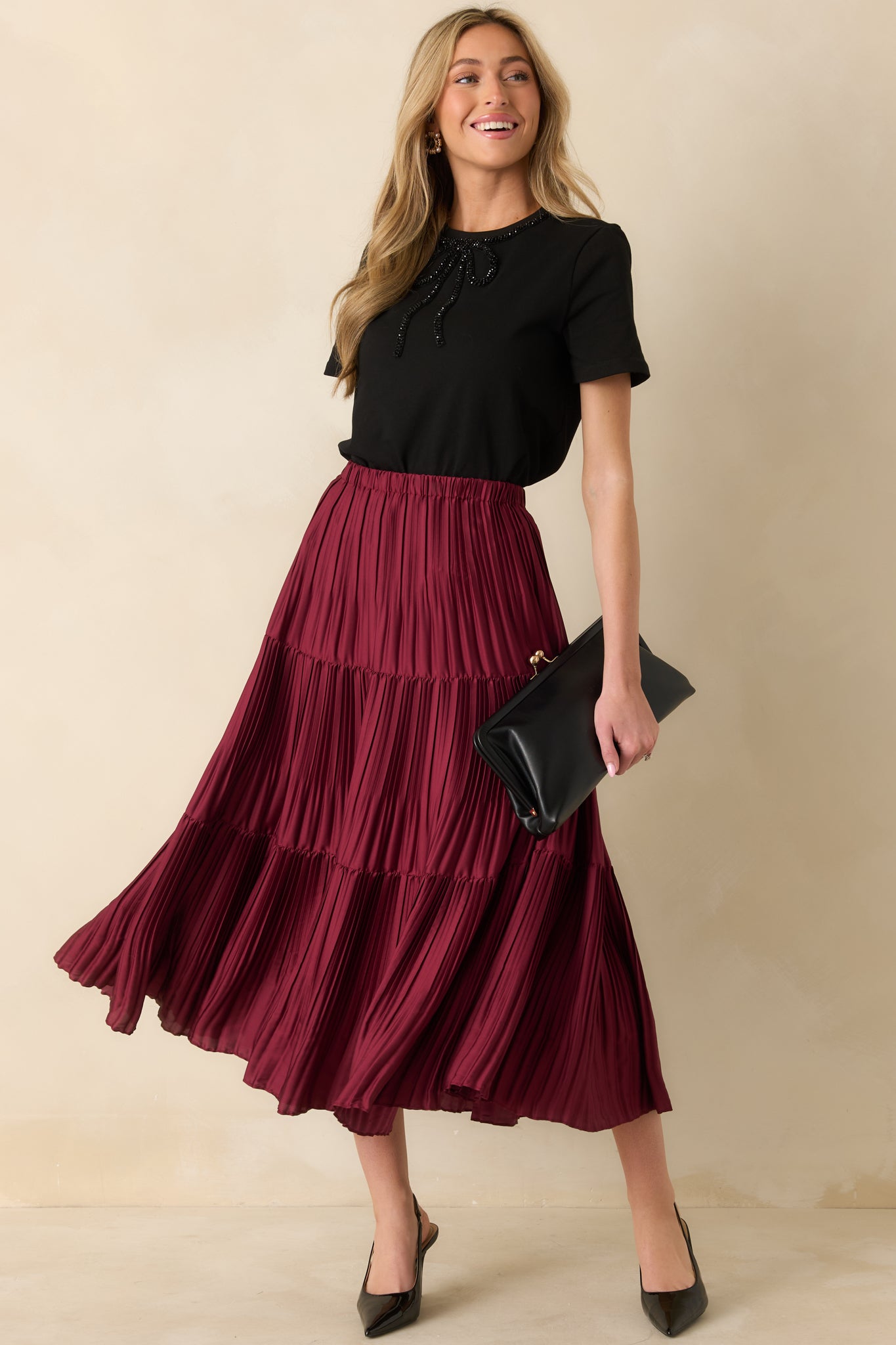 Front view of the black short sleeve top with crew neckline, beaded bow, and relaxed fit.