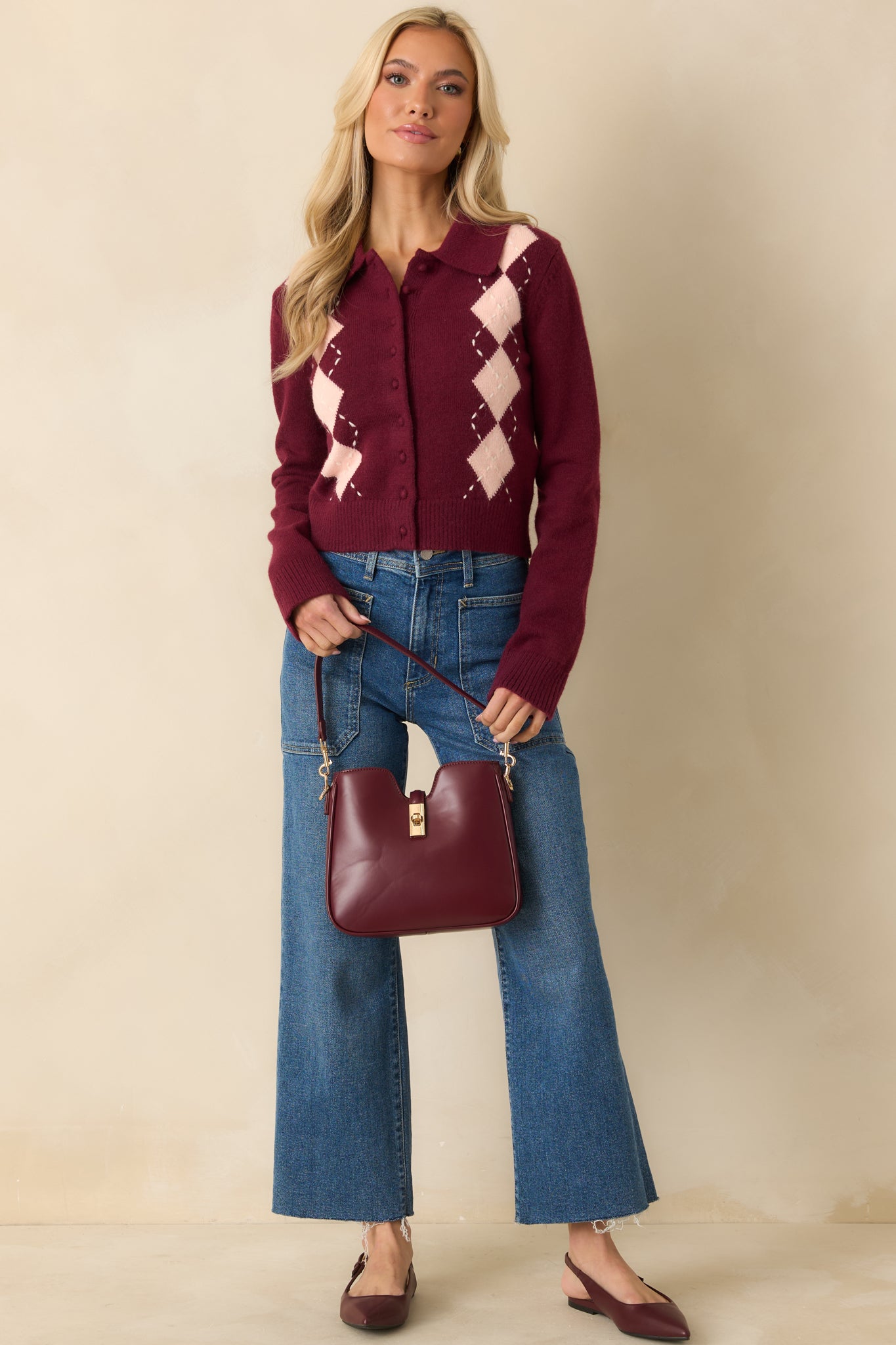 Front view of burgundy button-up cardigan with collared neckline, long sleeves, and cropped silhouette.