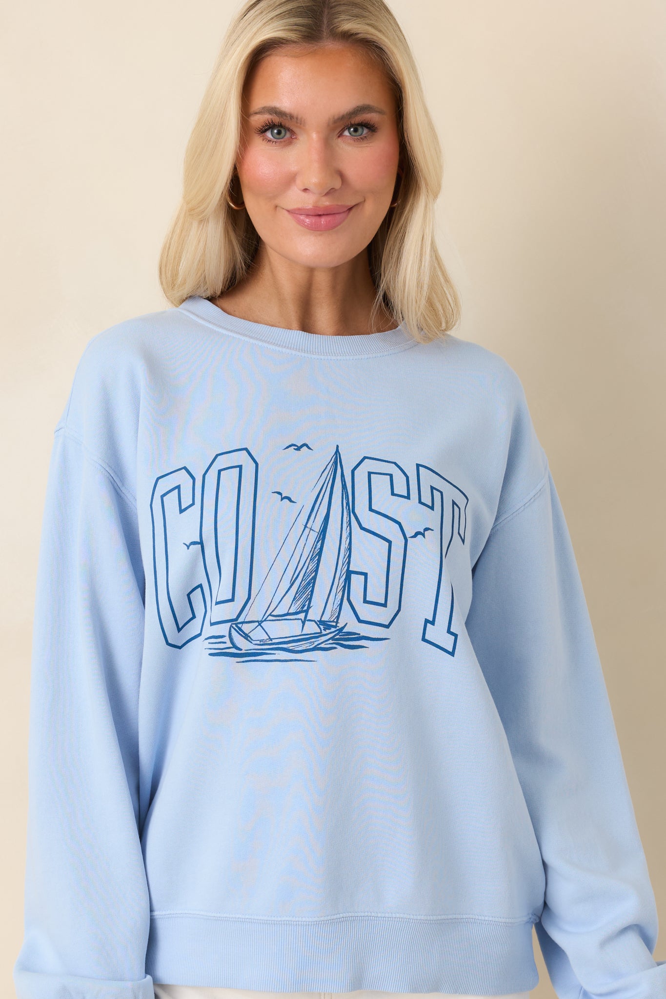 Front crop emphasizing the long sleeves with ribbed cuffs and relaxed pullover fit.