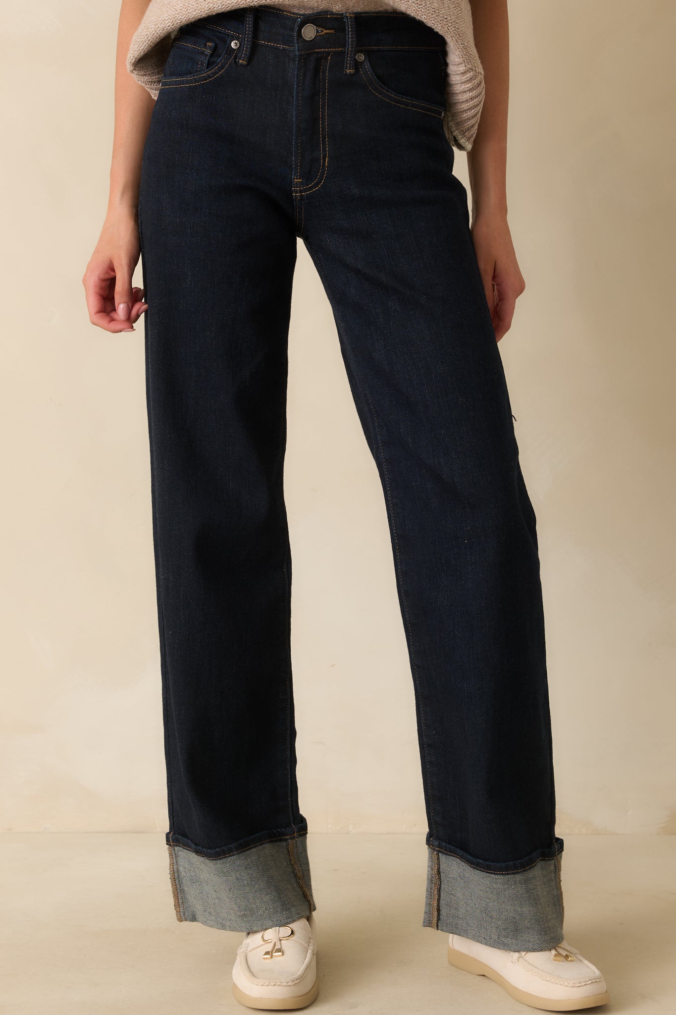 Front-focused crop highlighting wide-leg silhouette and cuffed hems of the dark denim jeans.