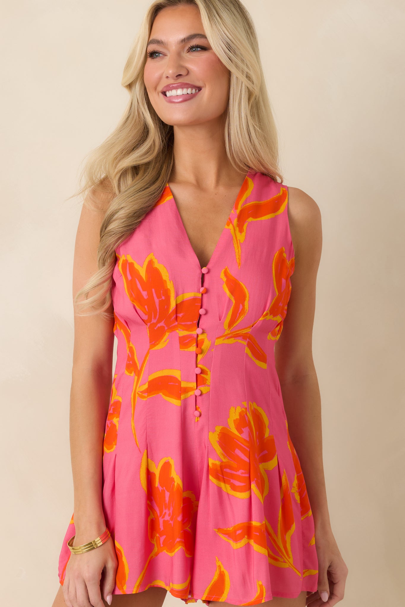 Front detail of sleeveless romper showcasing button accents and flattering flared short silhouette.