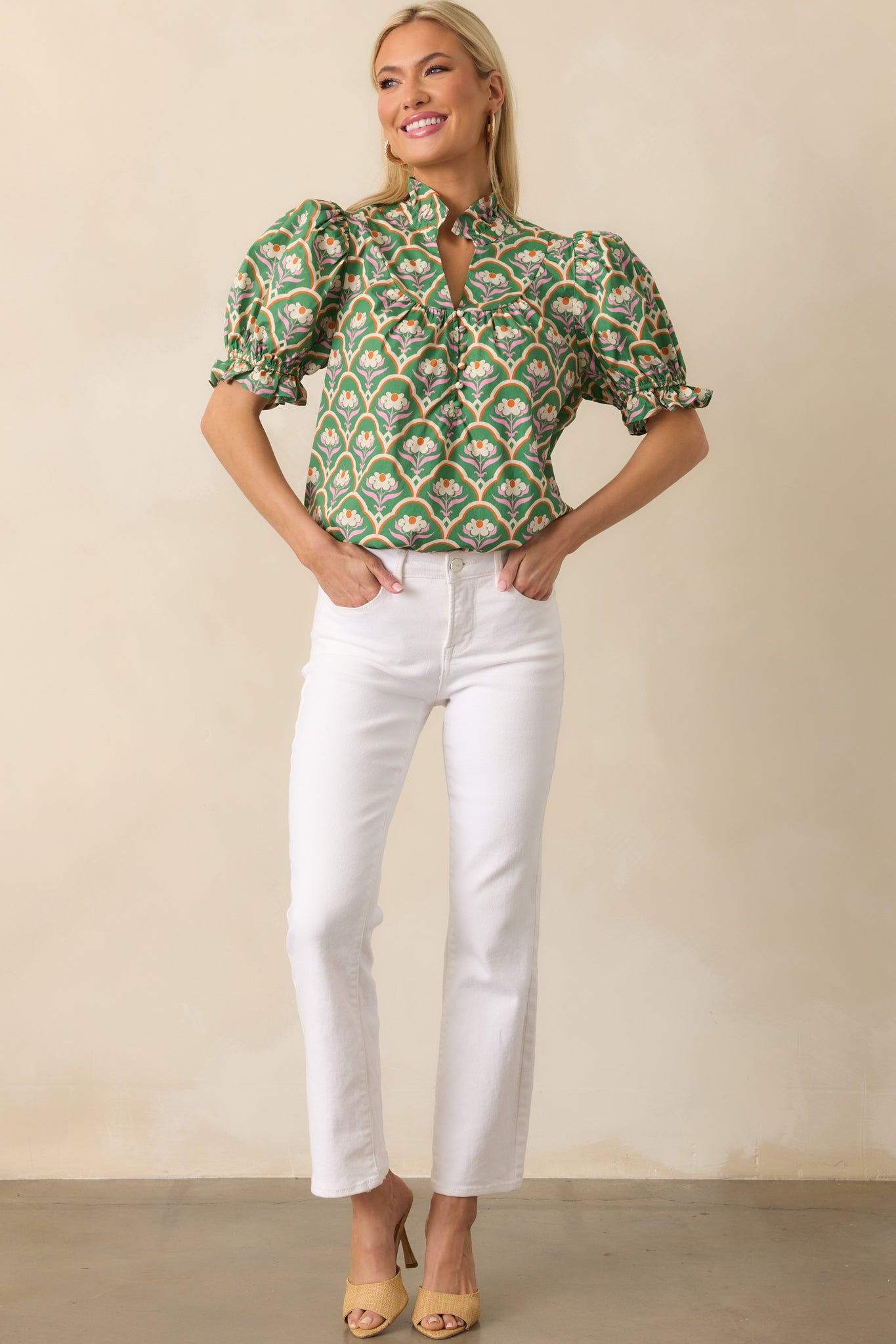 Front-facing green top highlighting structured puff sleeves and colorful ruffle details.