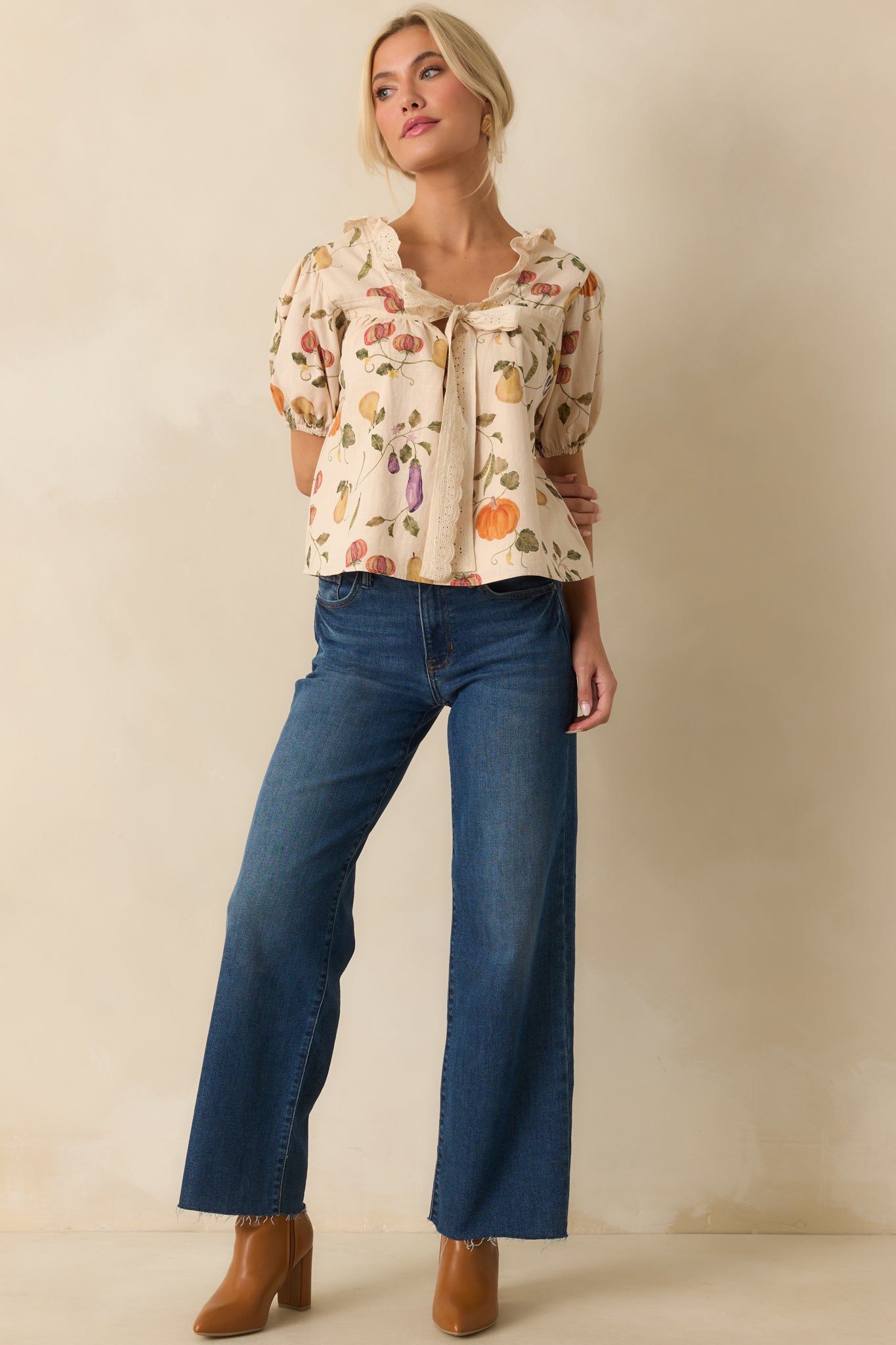 Front-facing display of ivory puff-sleeve blouse with vegetable motif and ruffled neckline.