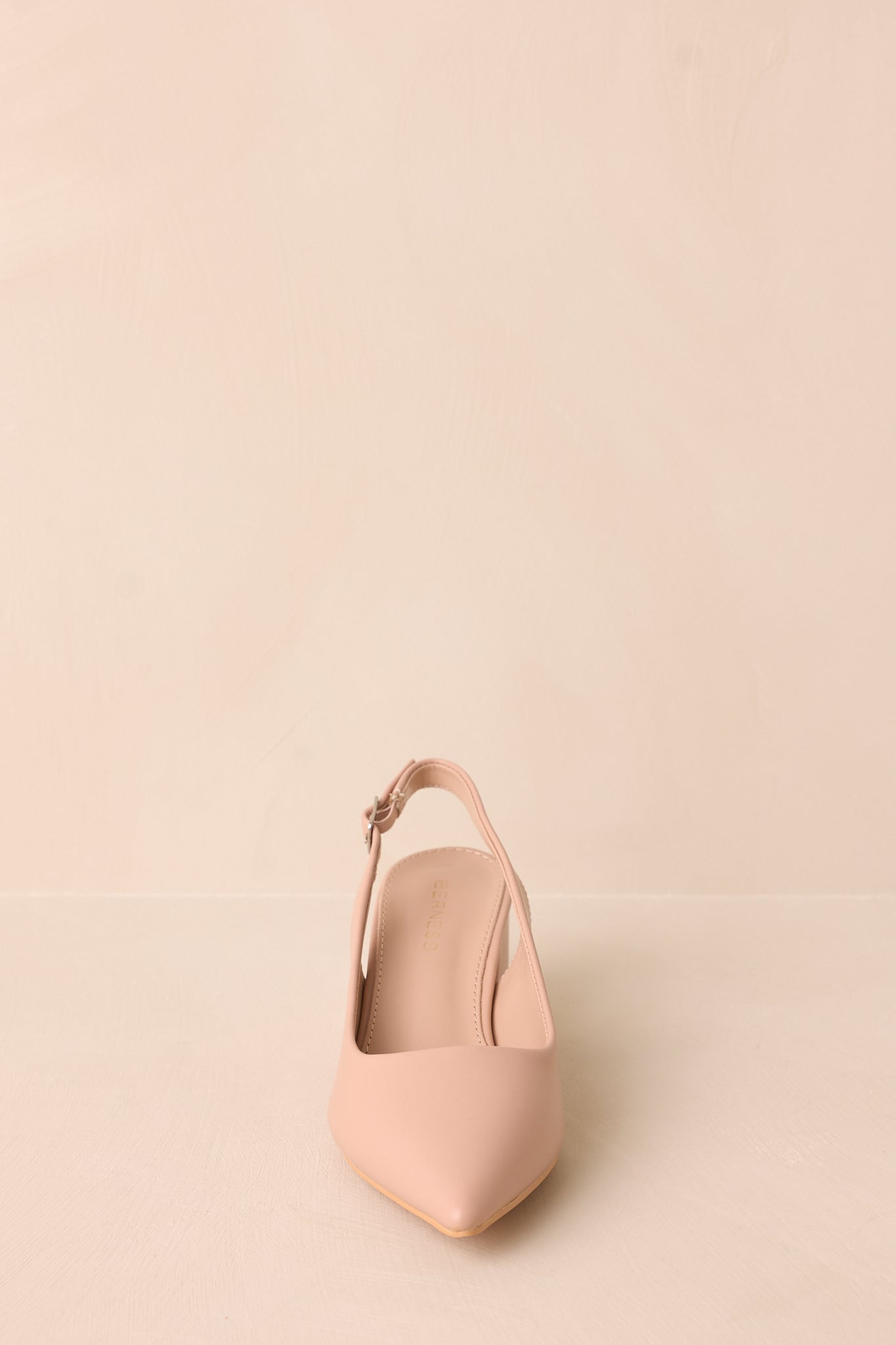 A direct front-facing perspective emphasizing the pointed toe shape and the structured design of the heels.