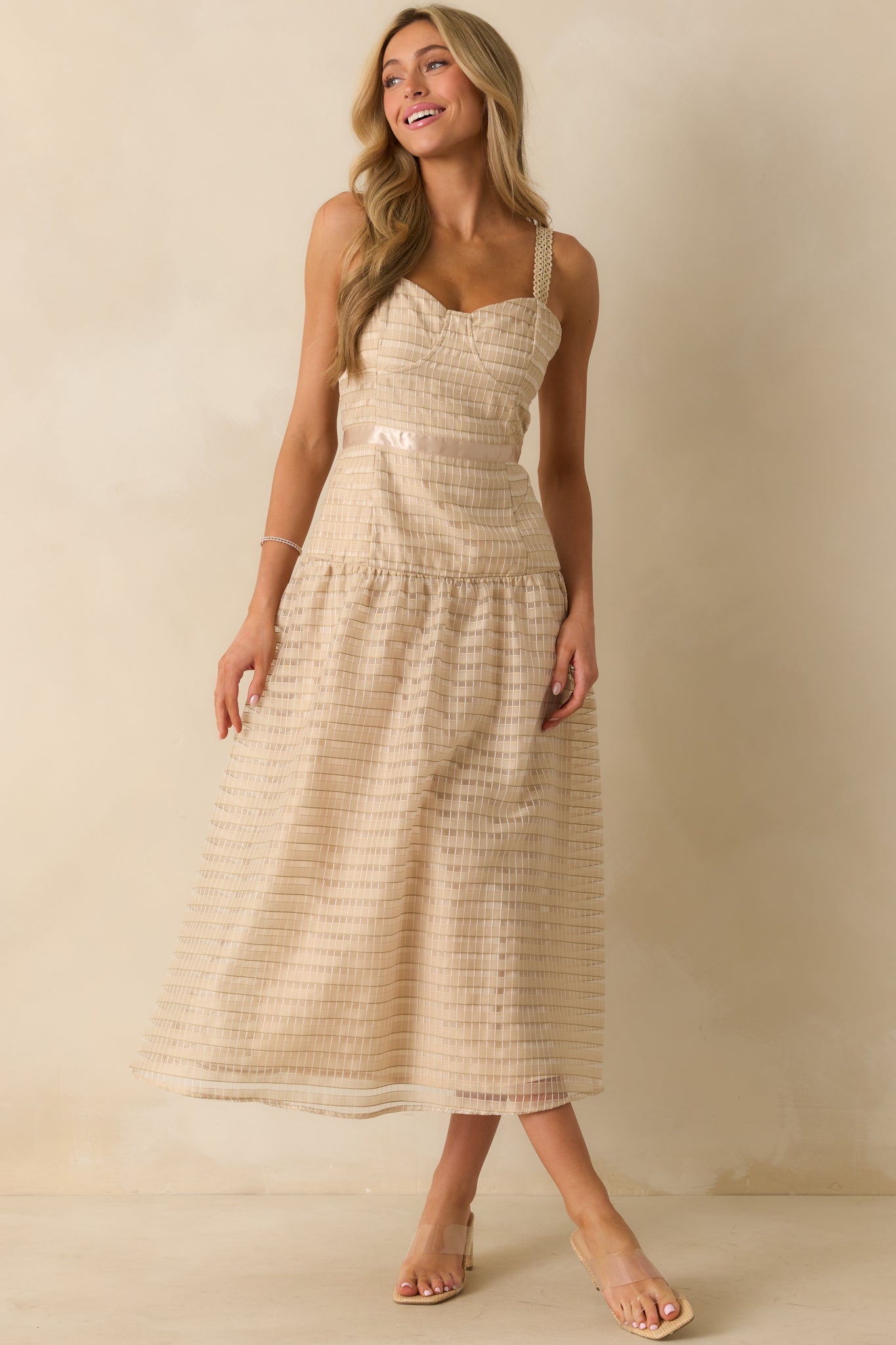 Front-facing shot of the tan embroidered dress, highlighting the ribbon waist and drop waist design.