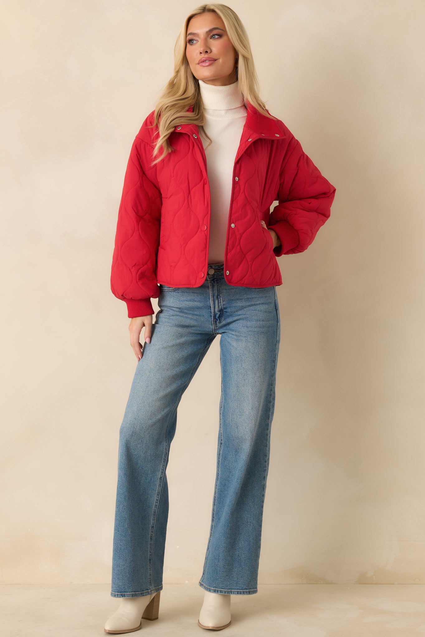 Front full-body shot highlighting the snap-front closure and lightweight padded quilting of the red jacket.