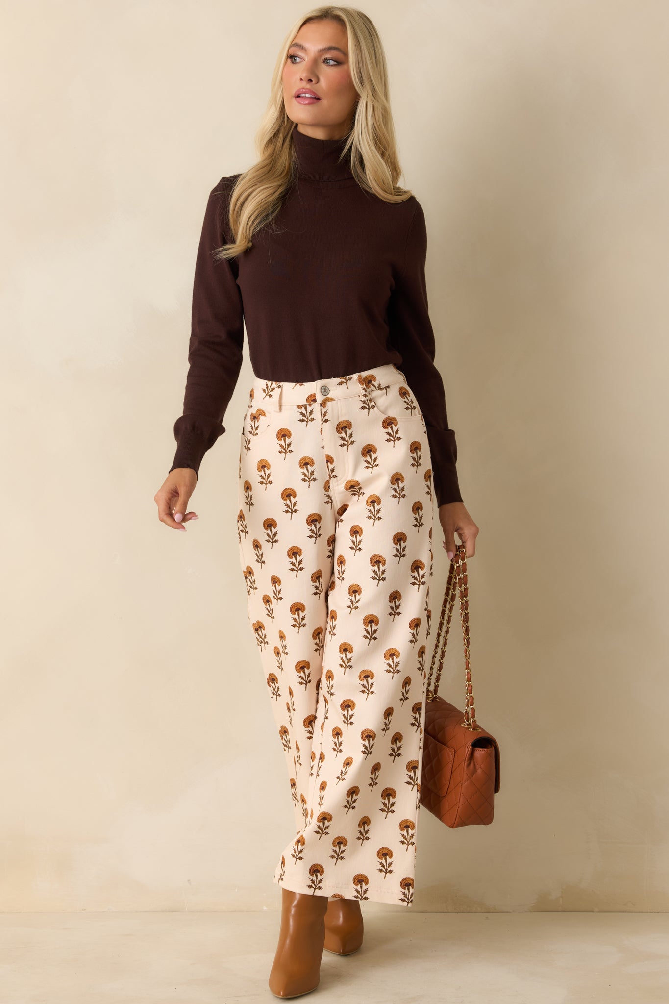 Front view of ivory floral wide leg pants highlighting the relaxed silhouette and vibrant marigold pattern.