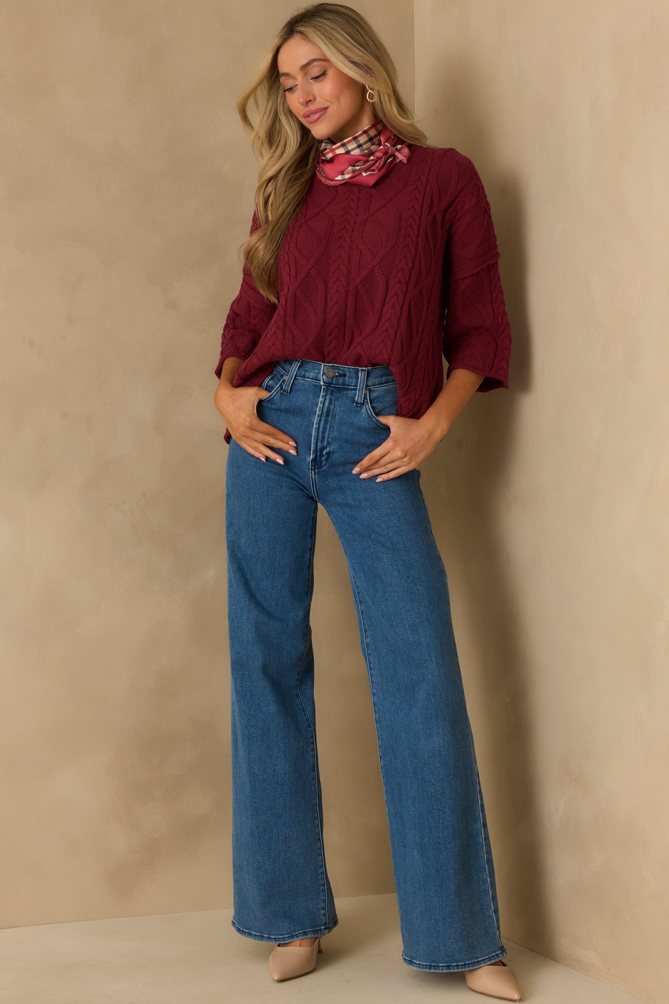 Front-facing look at the burgundy cable knit sweater with rolled hems and an easy, slightly loose silhouette.