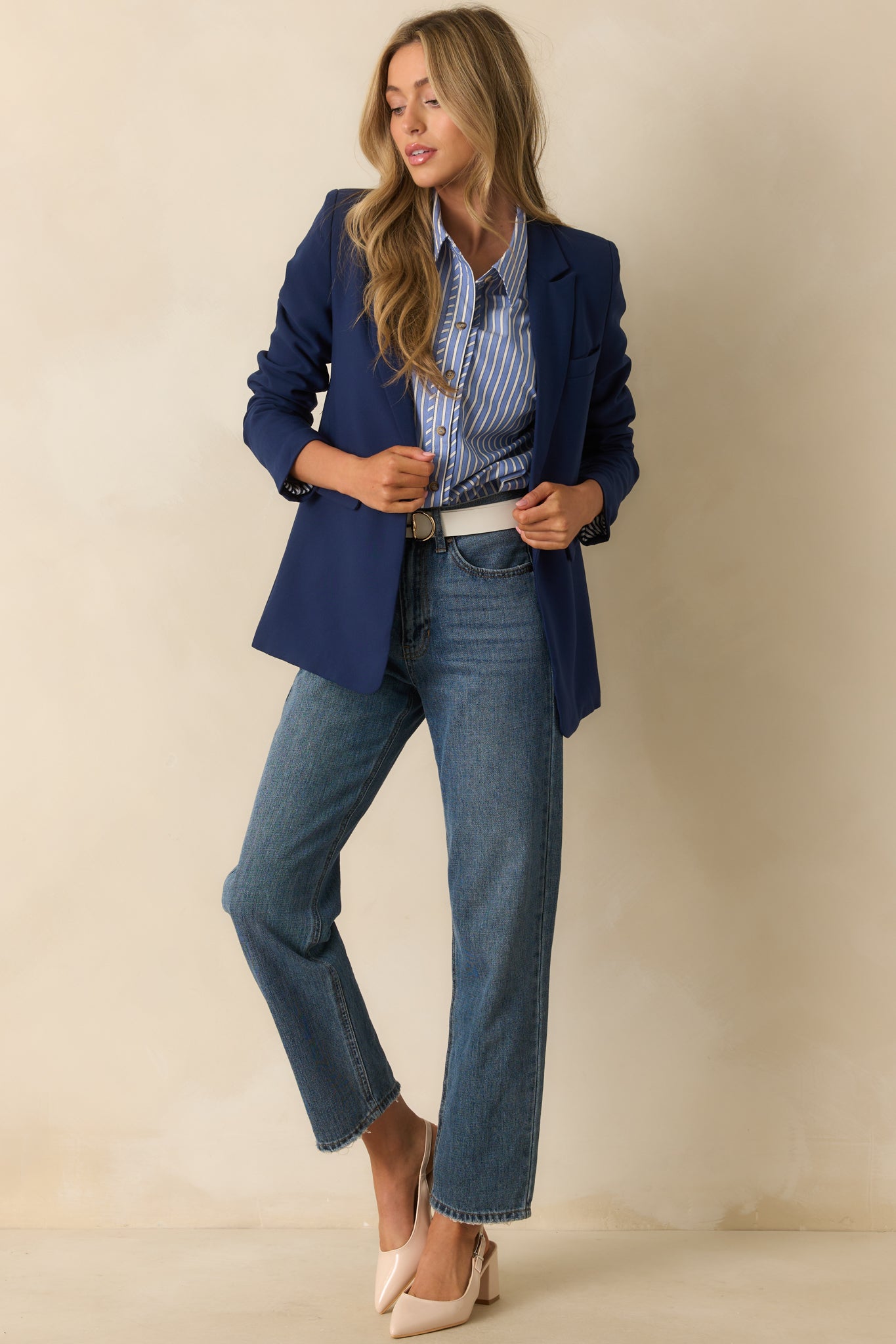 Front view of navy blazer featuring a collared lapel neckline and button front design.
