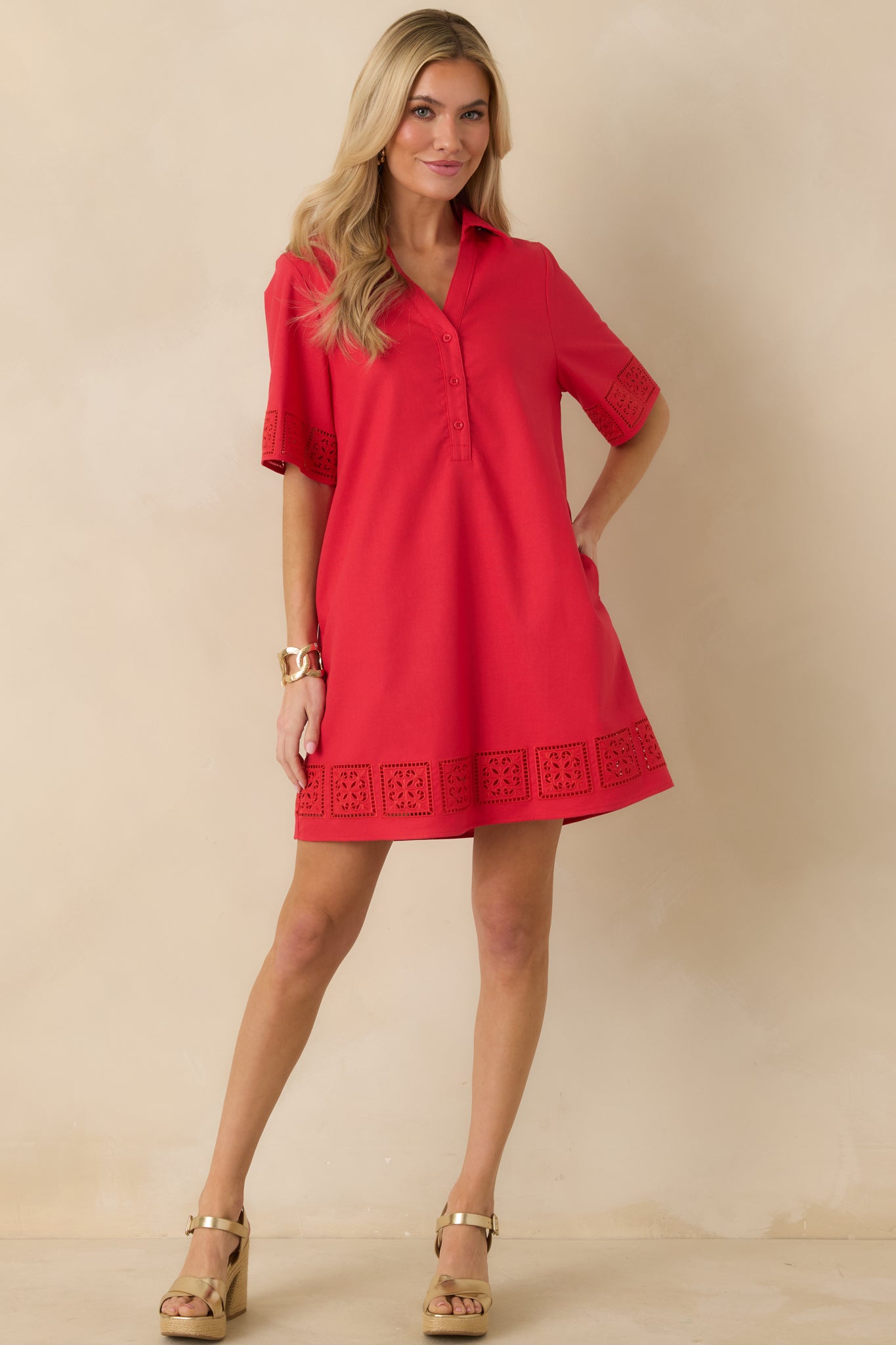 Angled front perspective highlighting the short sleeves, decorative cutout detailing along the cuffs and hem, and relaxed tailored fit.