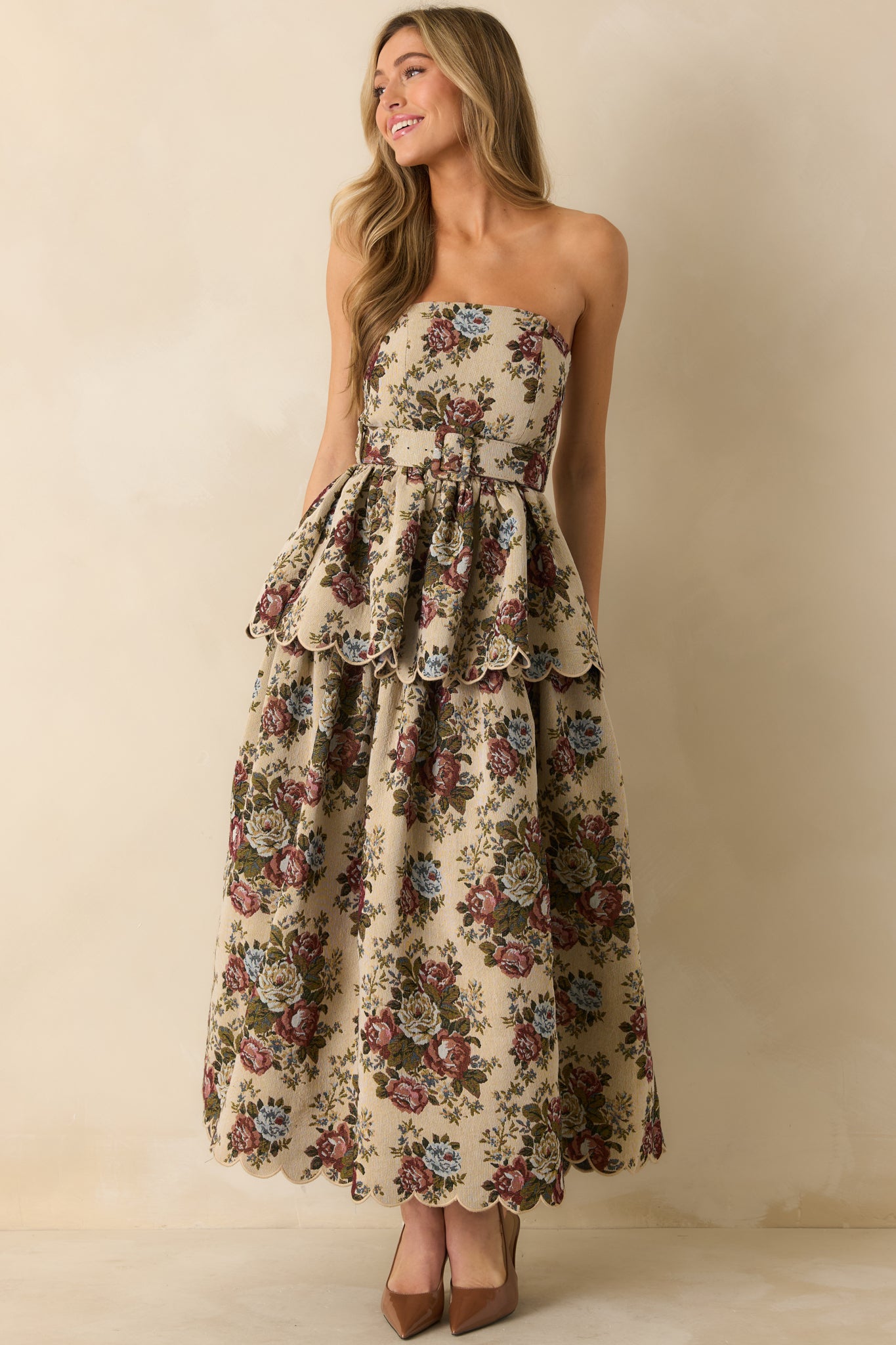 Front view of beige floral dress highlighting textured fabric and graceful tiered design.