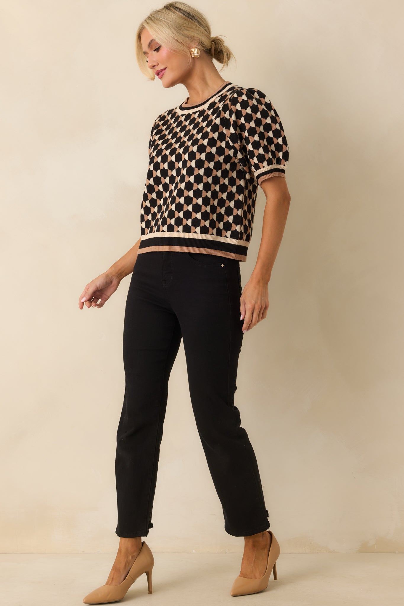 Front-facing black and beige top with ribbed cuffs and hem, puff sleeves, and subtle geometric print throughout.