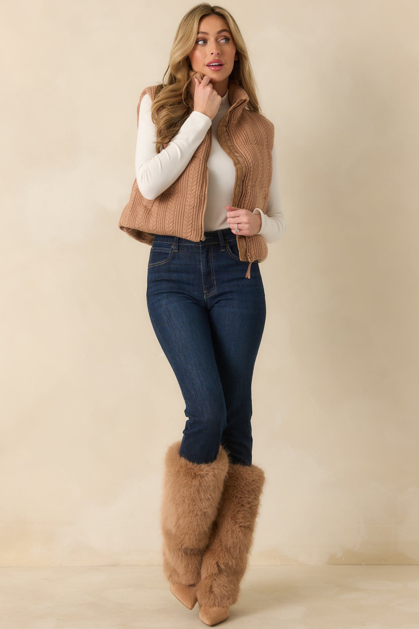 Front view of the camel brown puffer vest showing the quilted cable knit exterior, high stand collar, and zip-front closure with functional pockets.